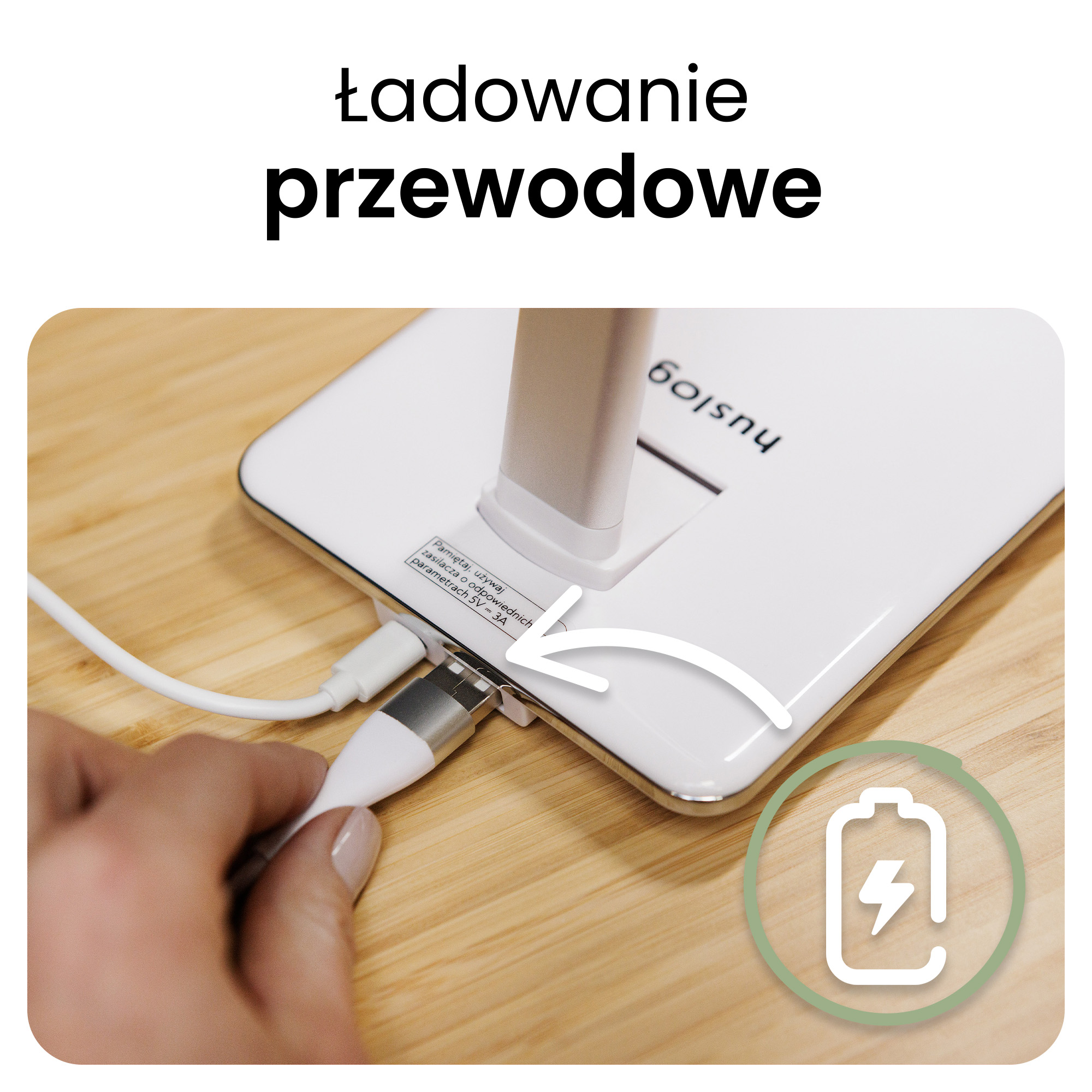 Dłoń podłącza biały kabel ładujący do białego urządzenia.