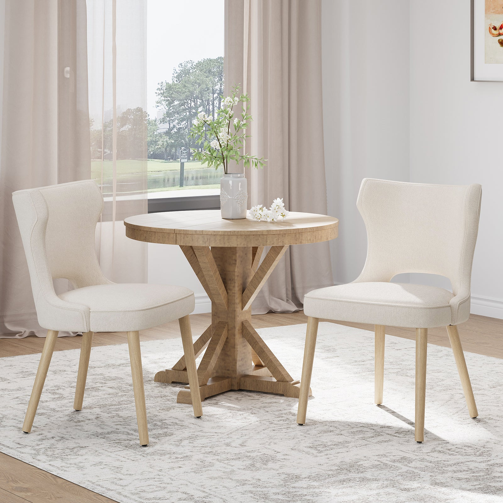 Zwei cremefarbene Stühle um einen Holztisch mit Blumen. Draußen Fenster mit See und Bäumen.