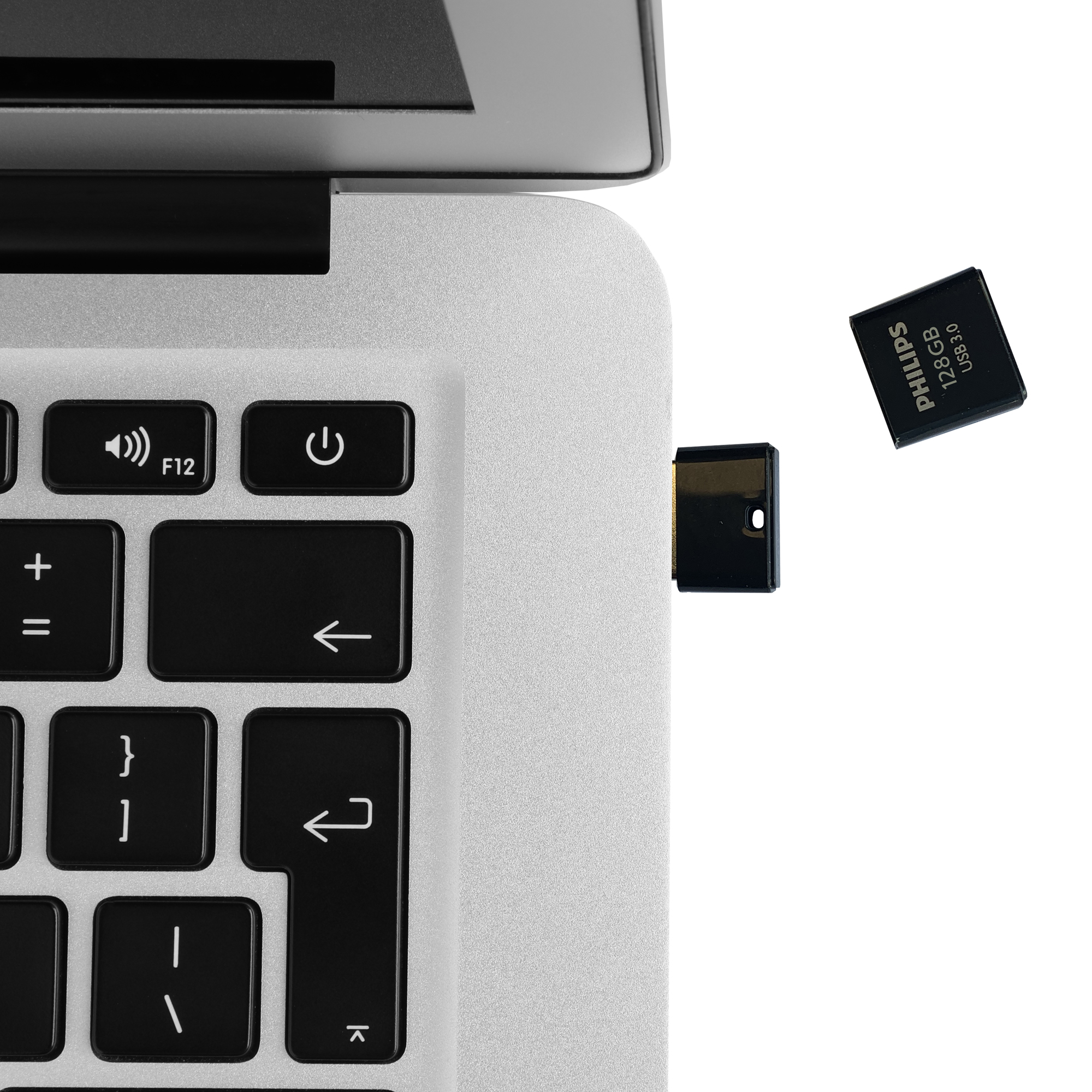 Ein schwarzer USB-Stick mit Philips 128GB USB 3.0 Aufschrift neben einer Computertastatur.
