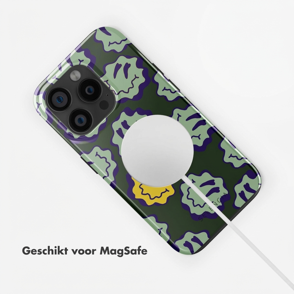 Coque verte pour iPhone avec motif de visages souriants fondus, chargeur MagSafe attaché.