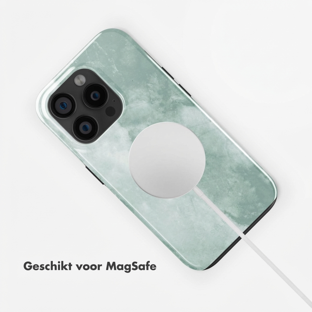 Un iPhone avec coque marbre vert et chargeur MagSafe.