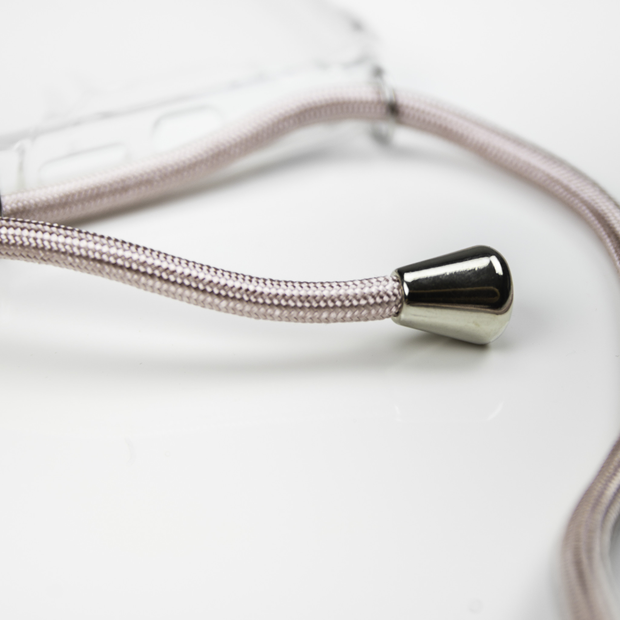 Een zilverkleurige metalen kegel is bevestigd aan een gevlochten koord op een witte ondergrond.