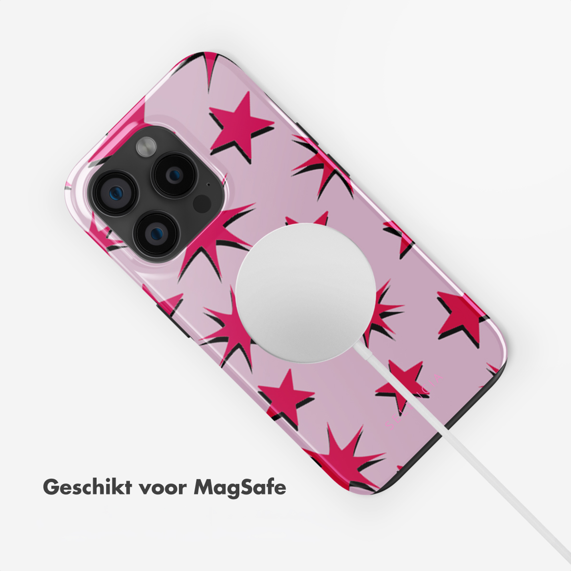 Une coque de téléphone rose avec des étoiles rouges et un chargeur MagSafe.