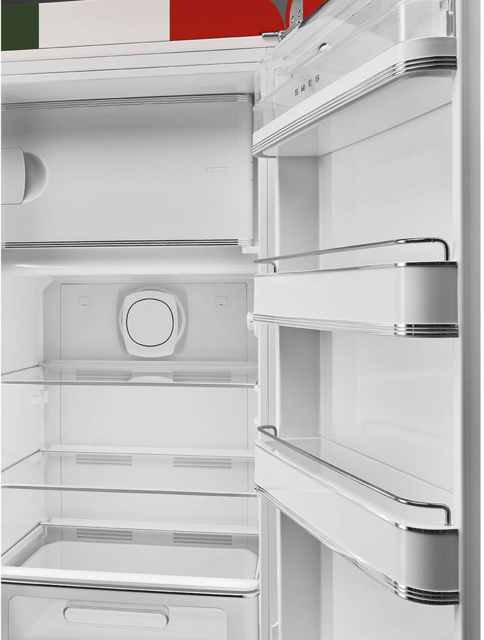 Interior abierto de frigorífico blanco SMEG con estantes y ventilación circular en la pared trasera.