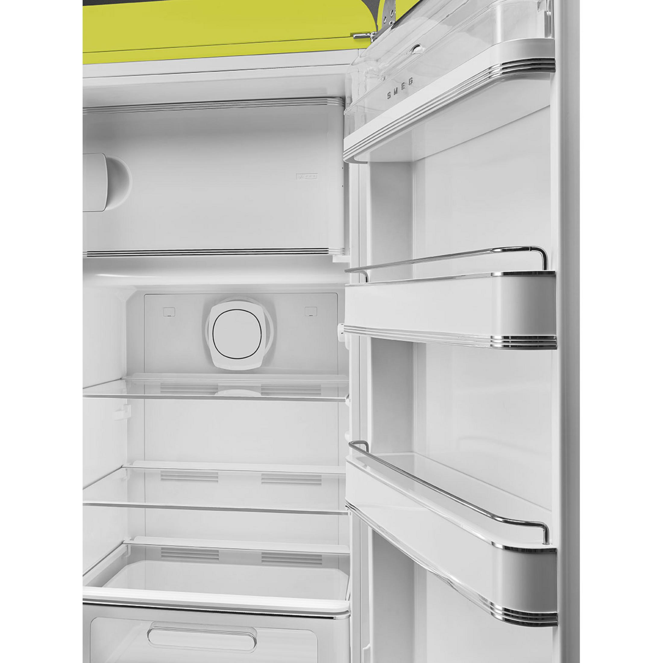 Un refrigerador abierto con parte superior amarilla, estantes blancos y una bandeja transparente.