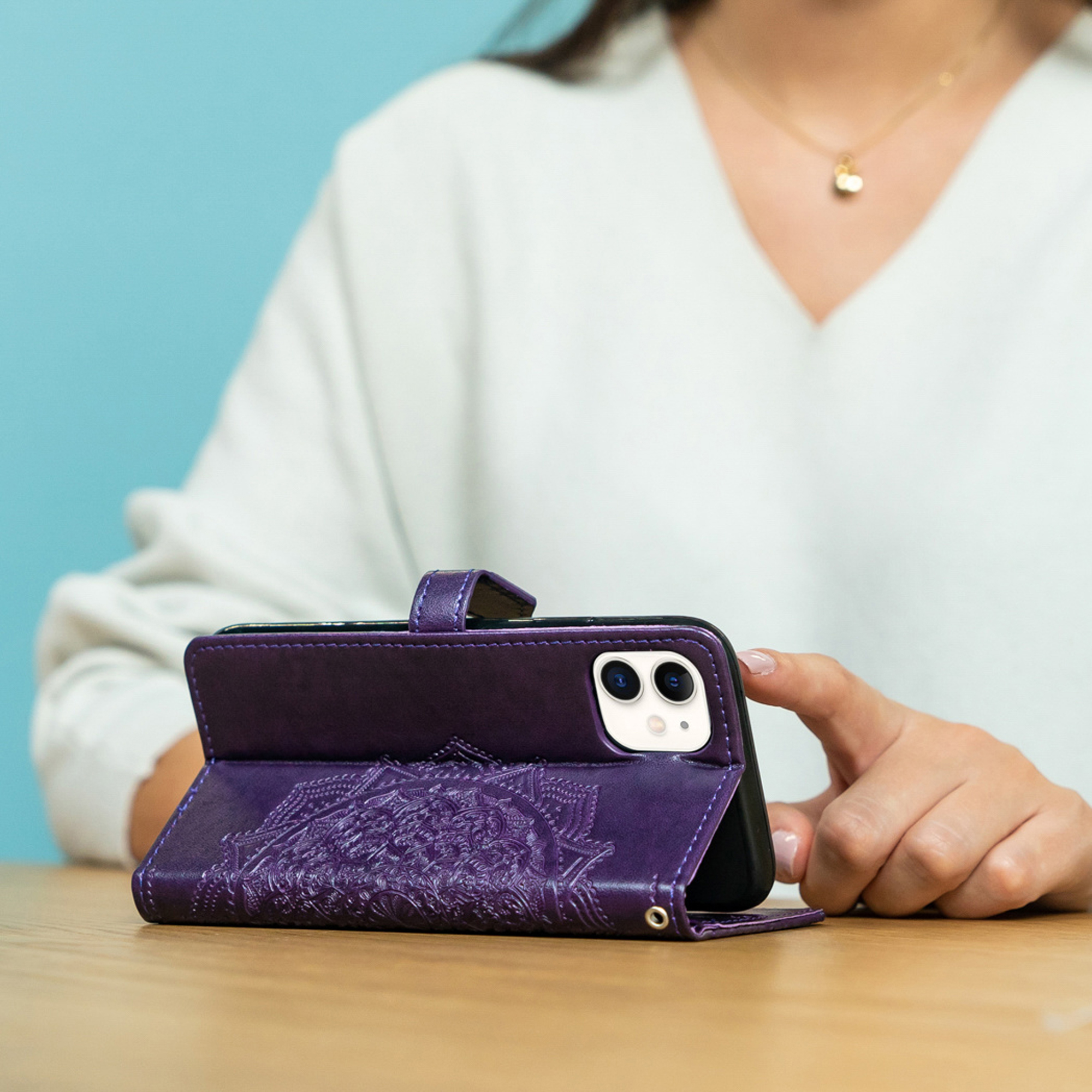 Una persona usa una custodia viola per telefono con mandala in rilievo.