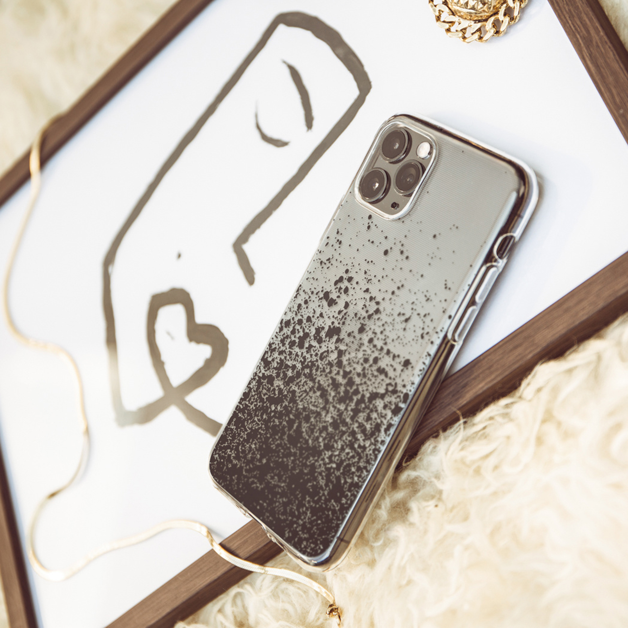 Un smartphone à motif tacheté repose sur une feuille blanche avec un dessin.