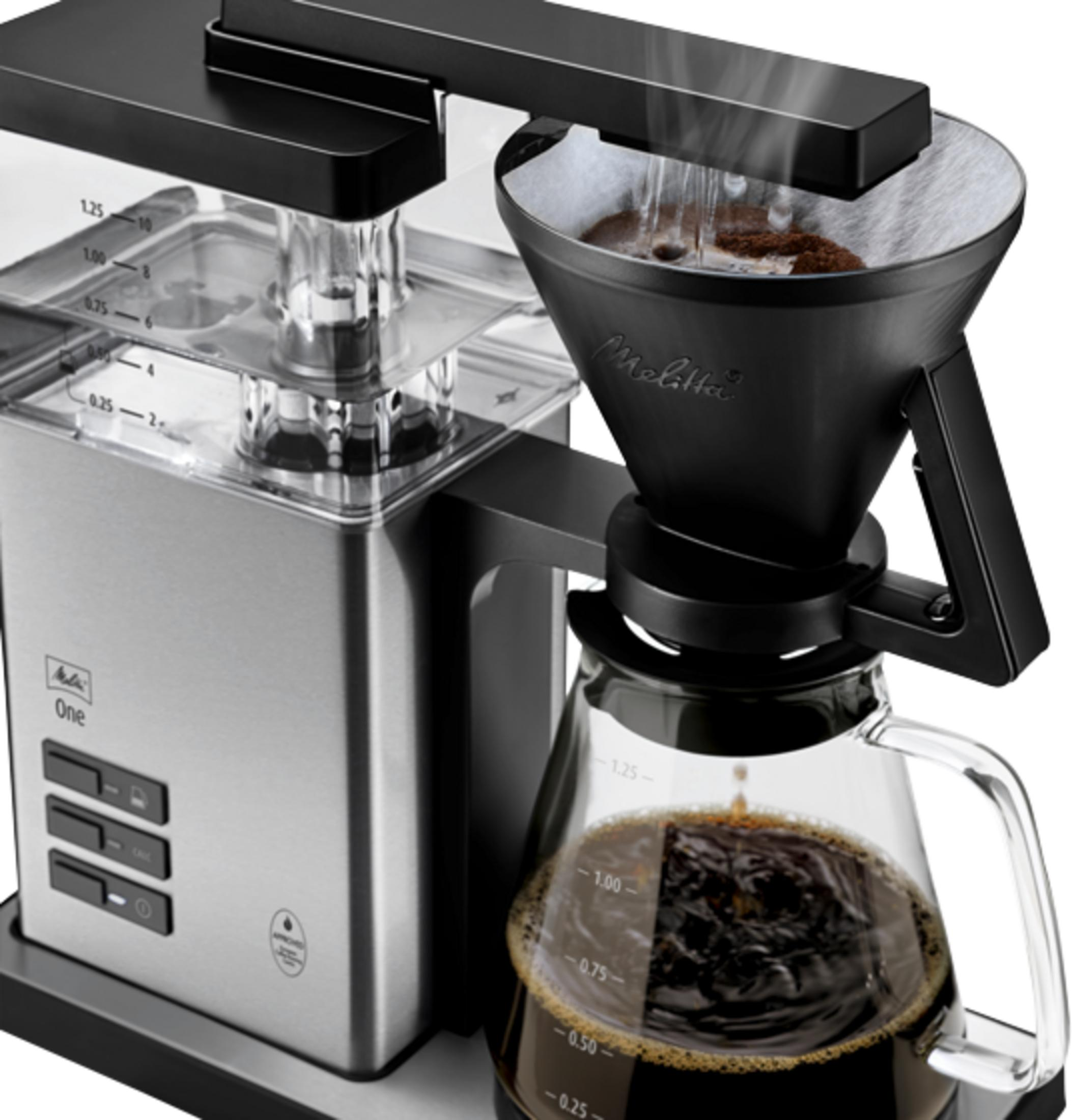 Une cafetière argentée et noire prépare du café dans une carafe en verre.