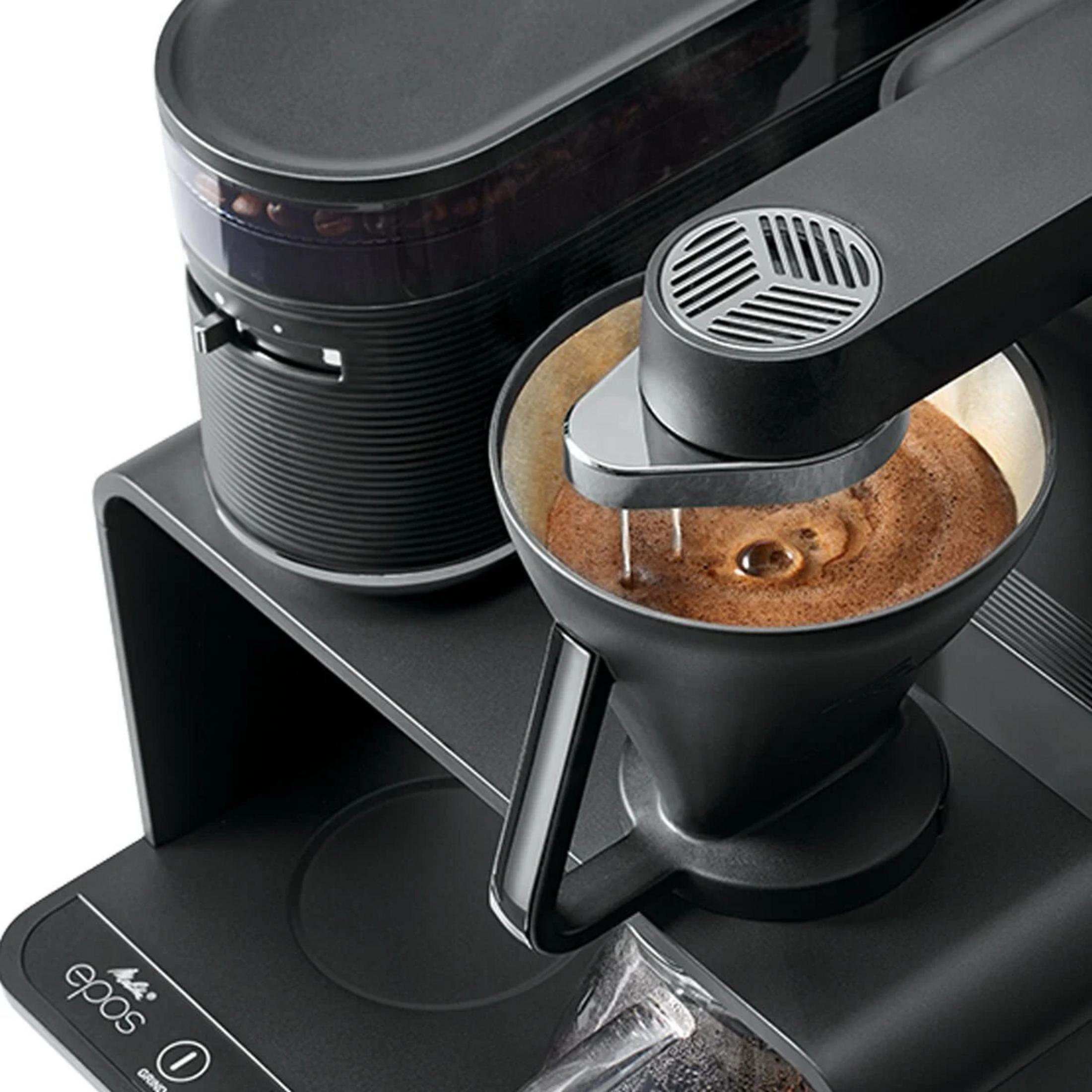 Eine schwarze Kaffeemaschine brüht Kaffee in einen Filter.