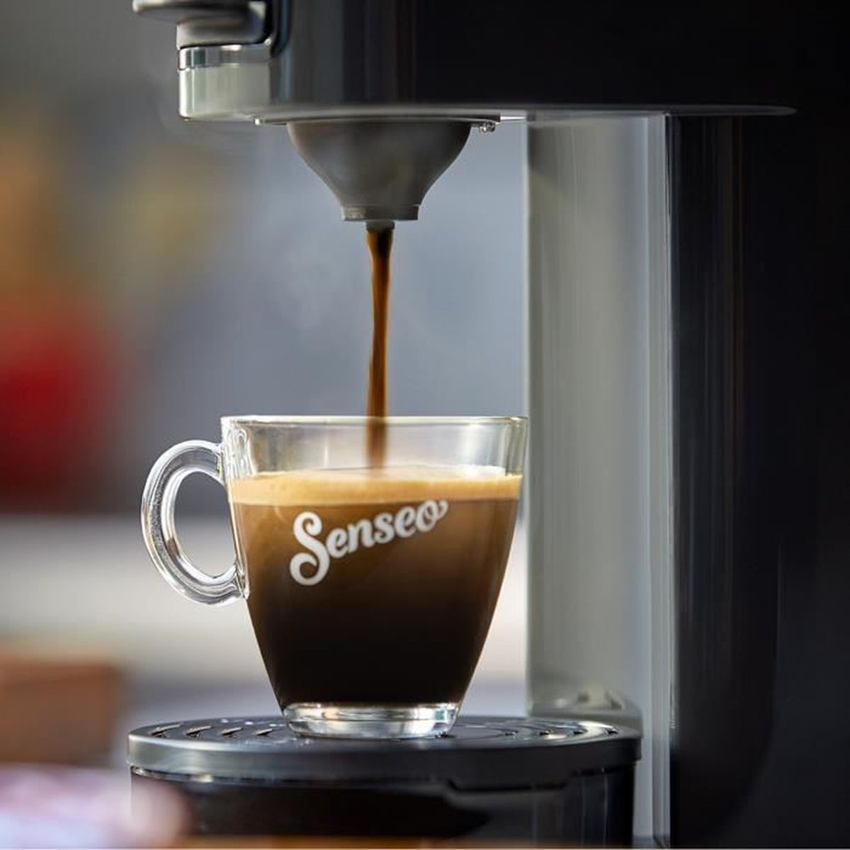 Il caffè scorre in una tazza trasparente Senseo su una macchina da caffè.