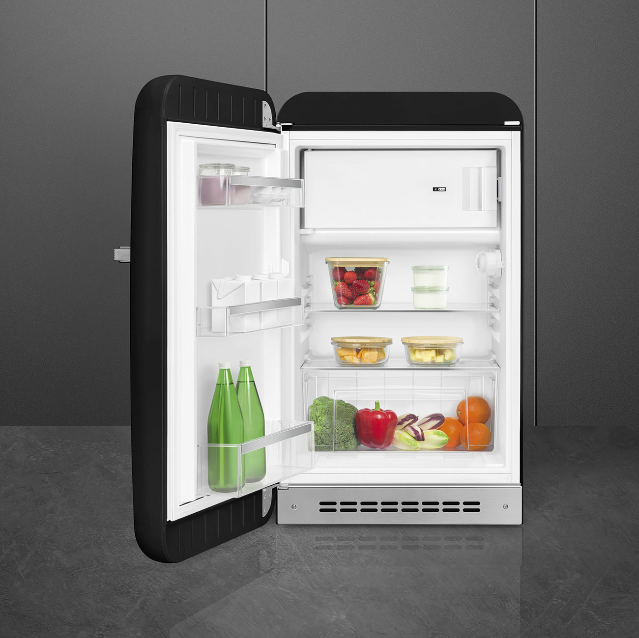 Refrigerador negro abierto con comida y bebidas dentro.
