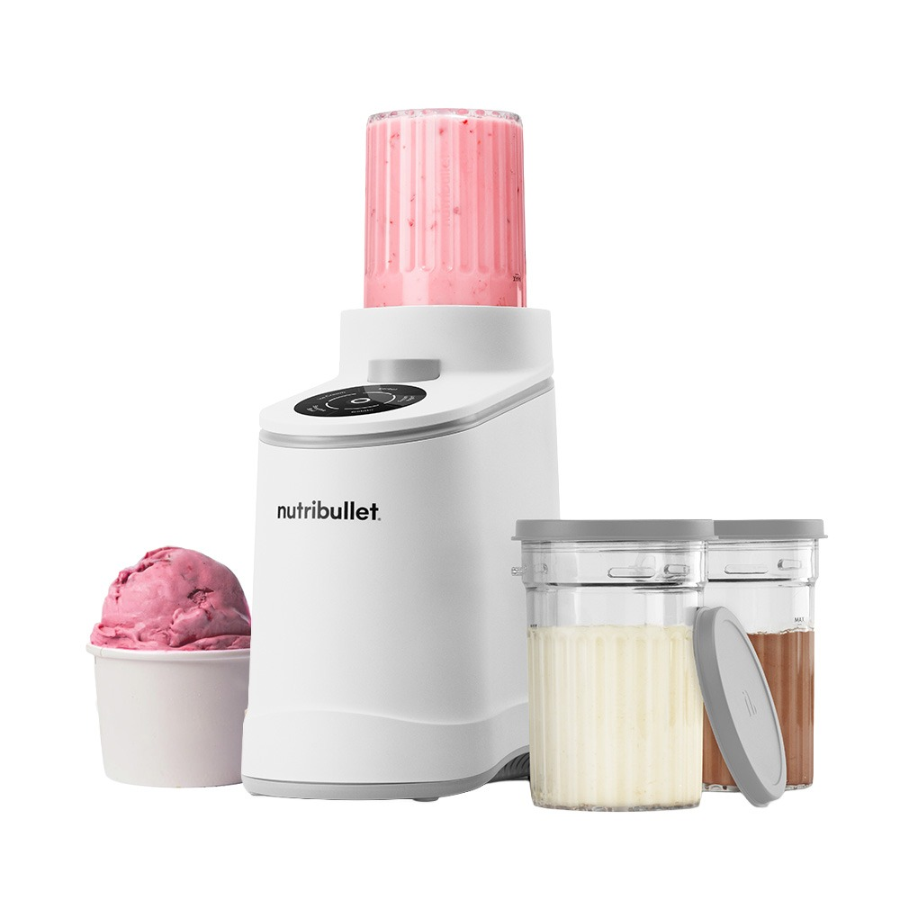 Ein weißer Nutribullet Mixer mit einem Becher voller rosa Smoothie, Eis und zwei Behältern.