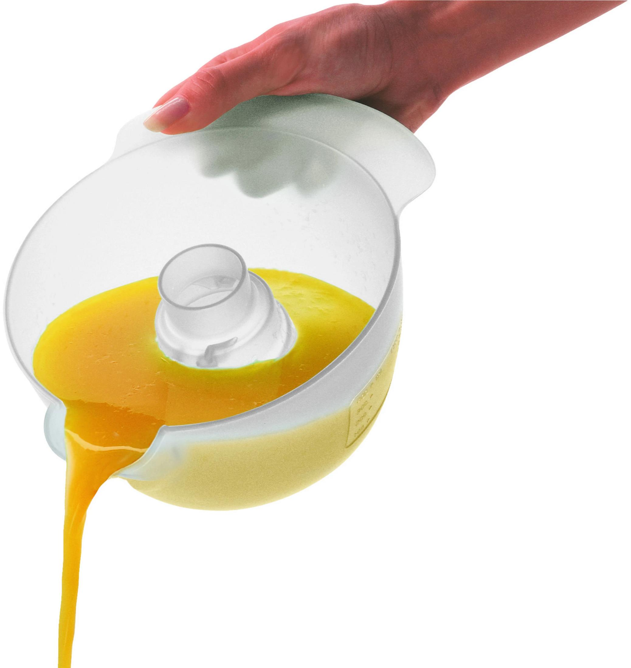 A hand tilts a clear container, pouring out a yellow liquid.