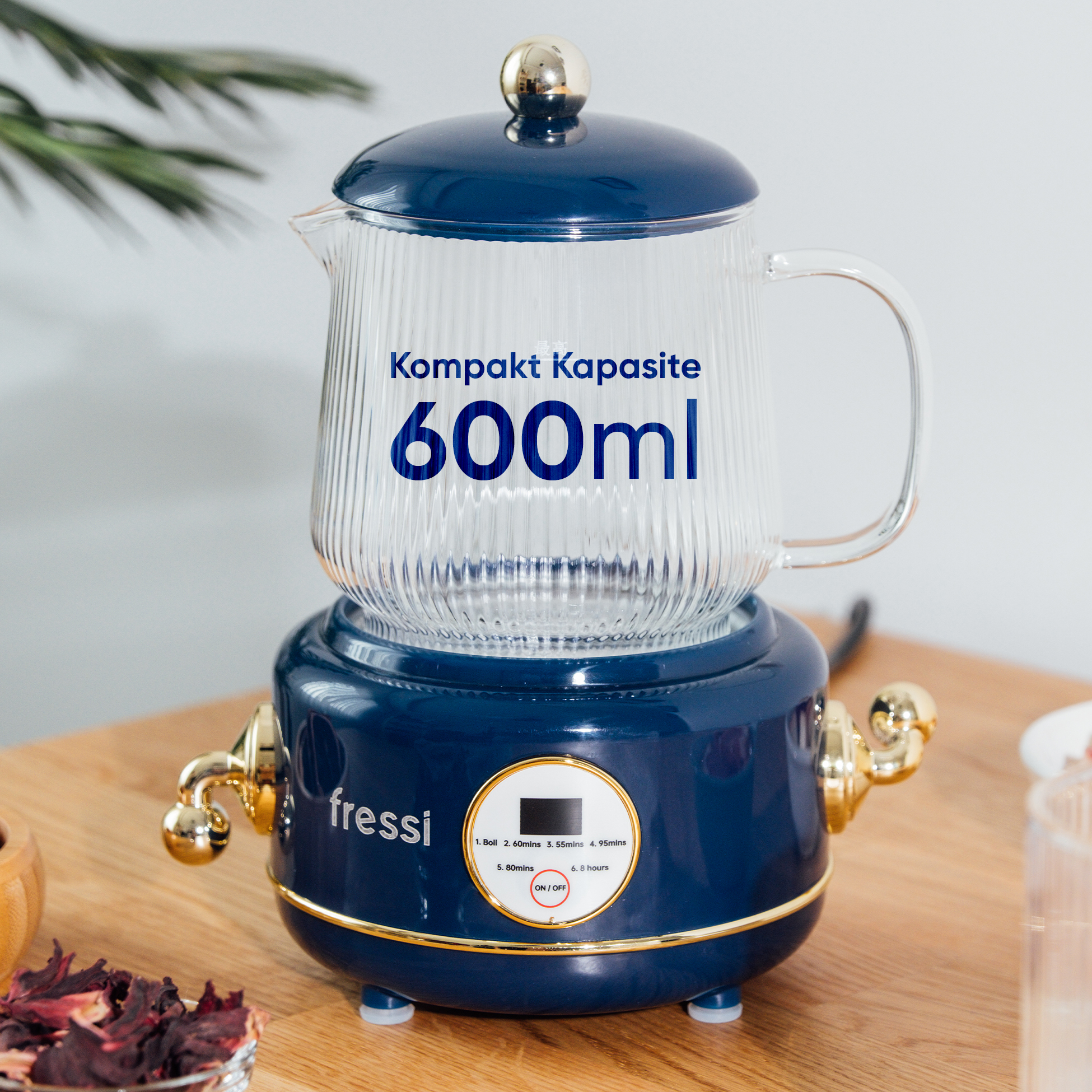 Cam kapaklı mavi su ısıtıcı, 600ml kapasite, ahşap masa üzerinde.