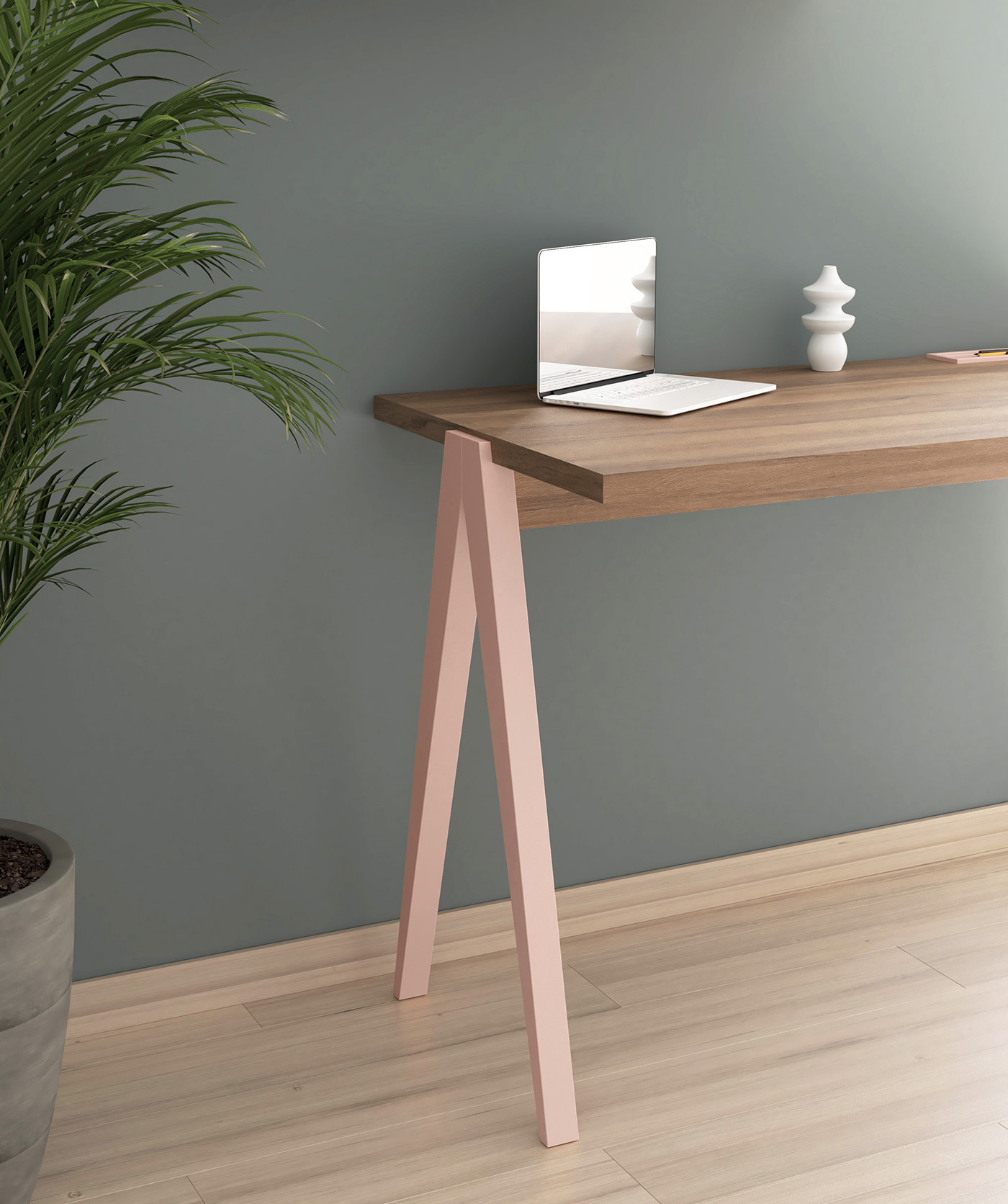 Un escritorio de madera con patas rosas, un portátil y un jarrón.