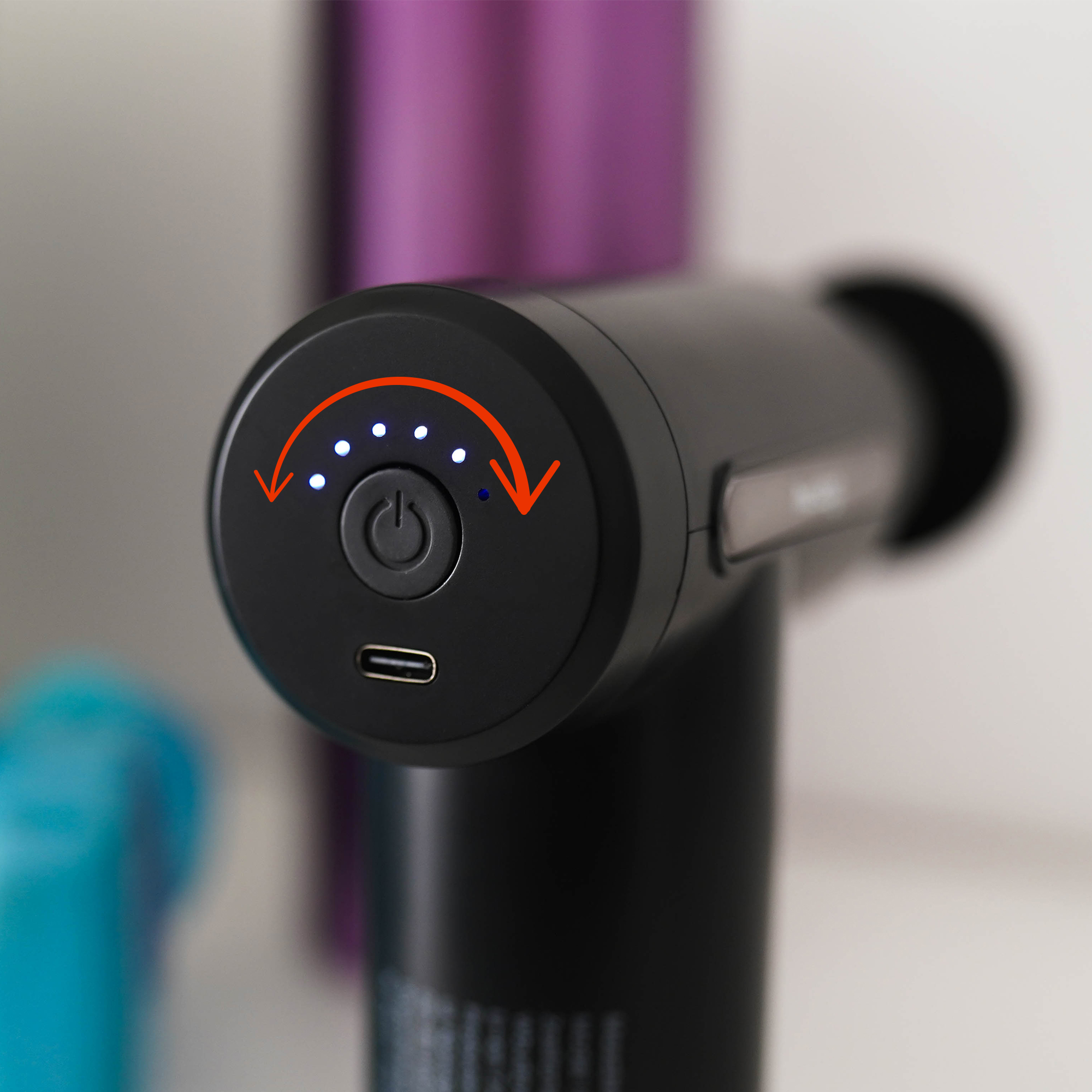 Czarna głowica pistoletu do masażu z przyciskiem zasilania, wskaźnikami naładowania i portem USB-C.