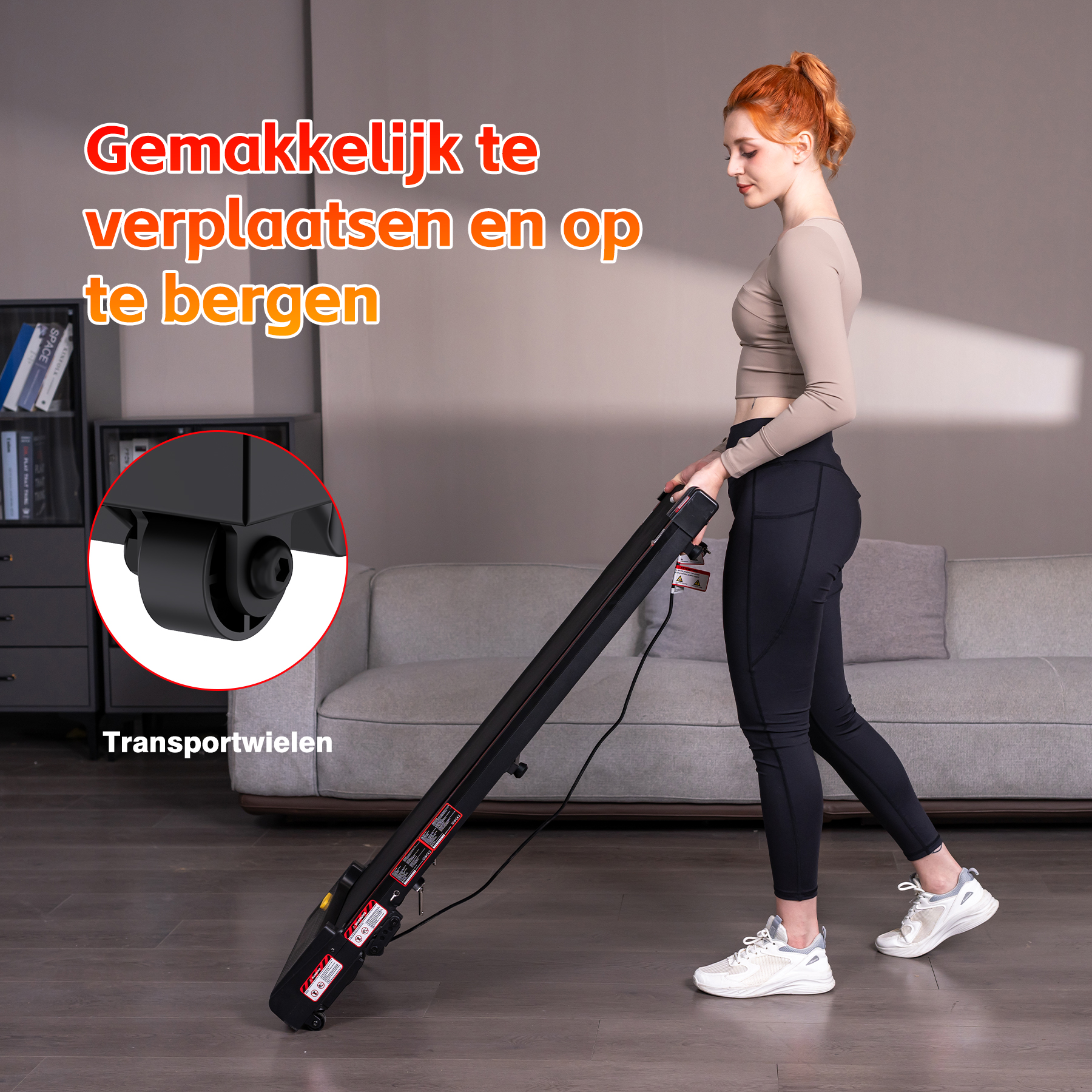 A woman with red hair pushes a black treadmill with transport wheels.