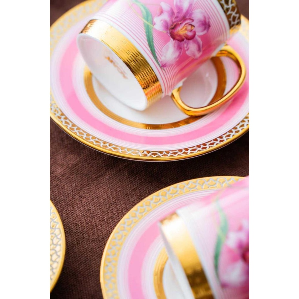 Orkide desenli pembe fincan ve altın rengi detaylı fincan tabağı.