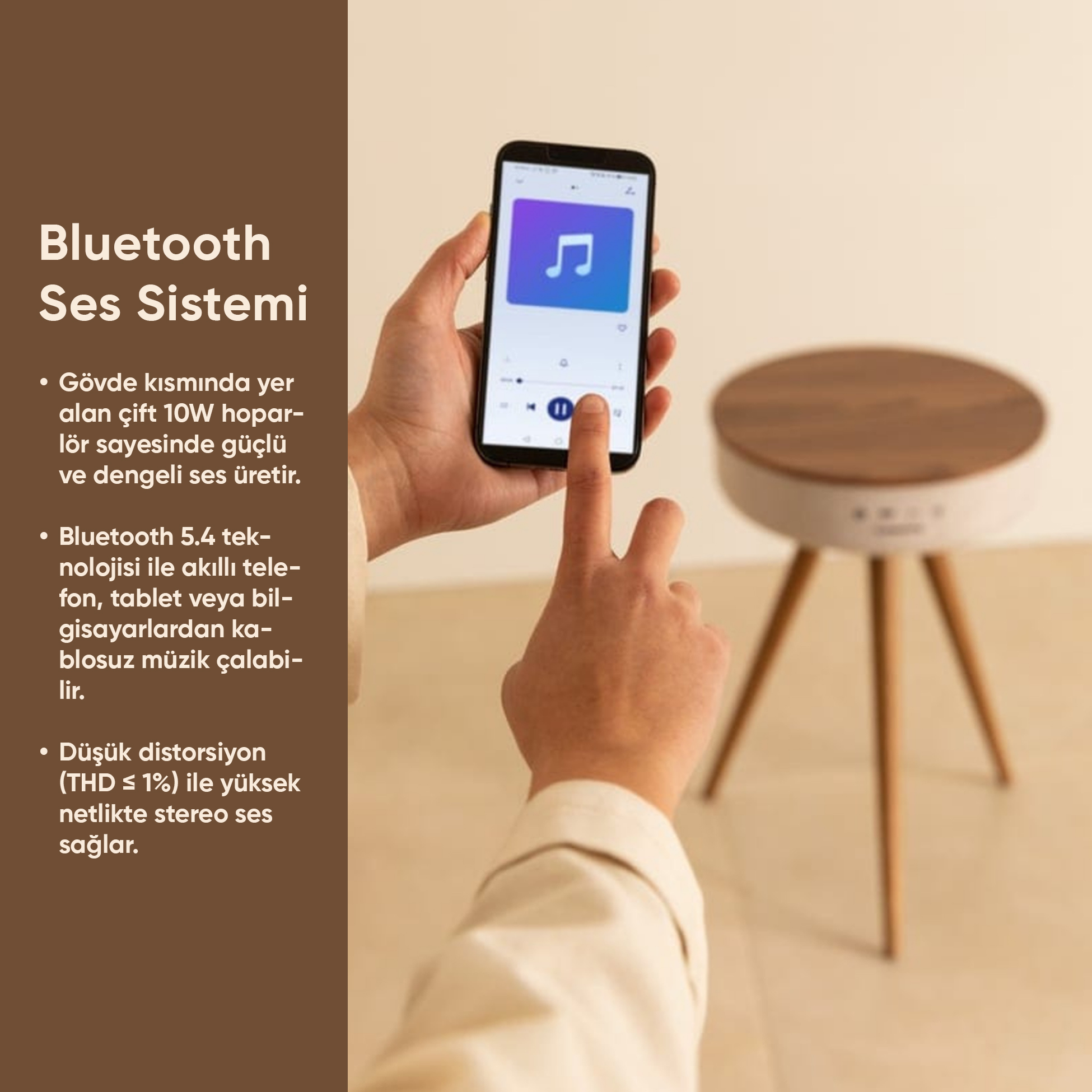 Müzik uygulamalı akıllı telefon tutan el; ahşap üstlü hoparlör üç ayak üzerinde.