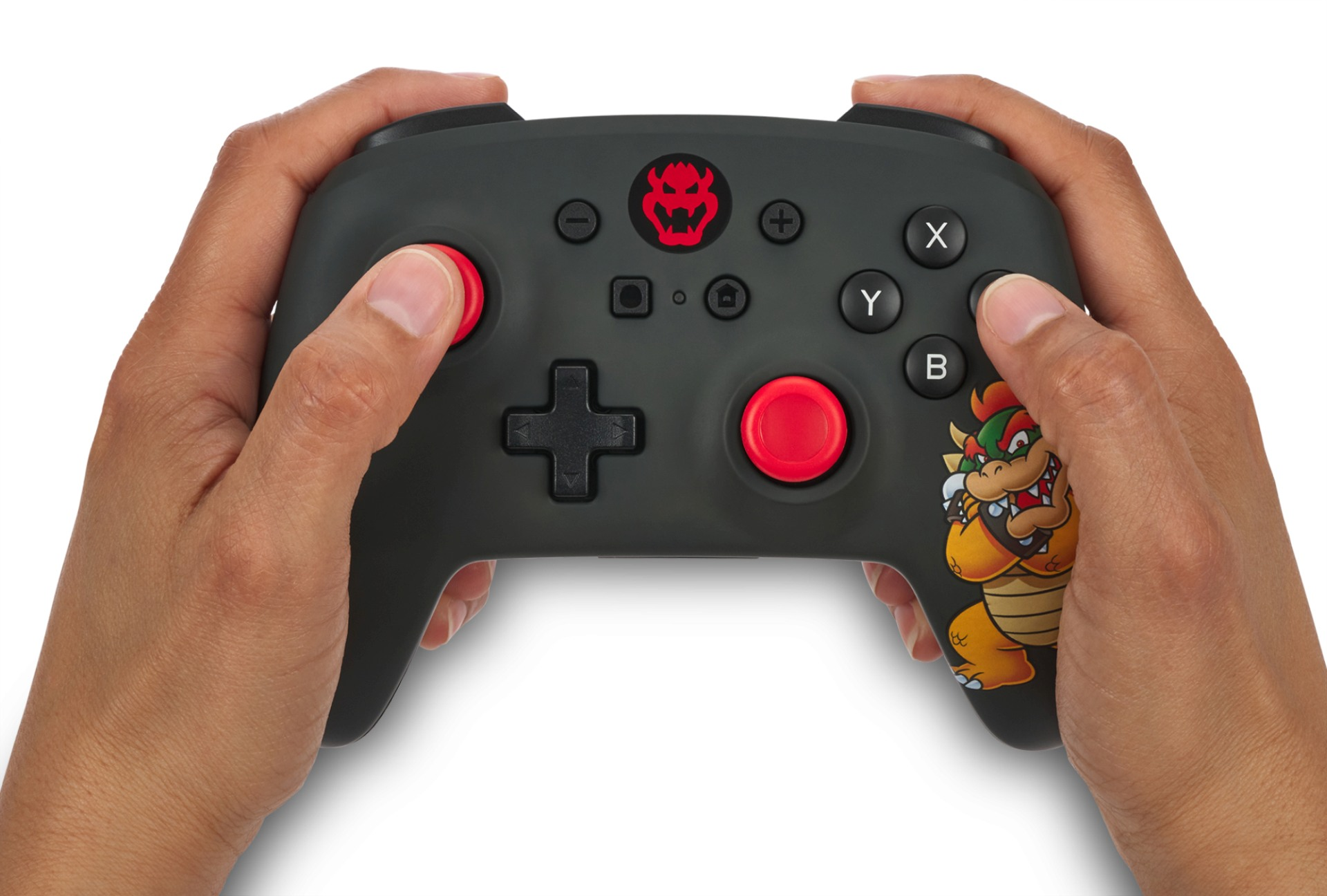 Hände halten einen schwarzen Controller mit roten Knöpfen und Bowser-Motiv.