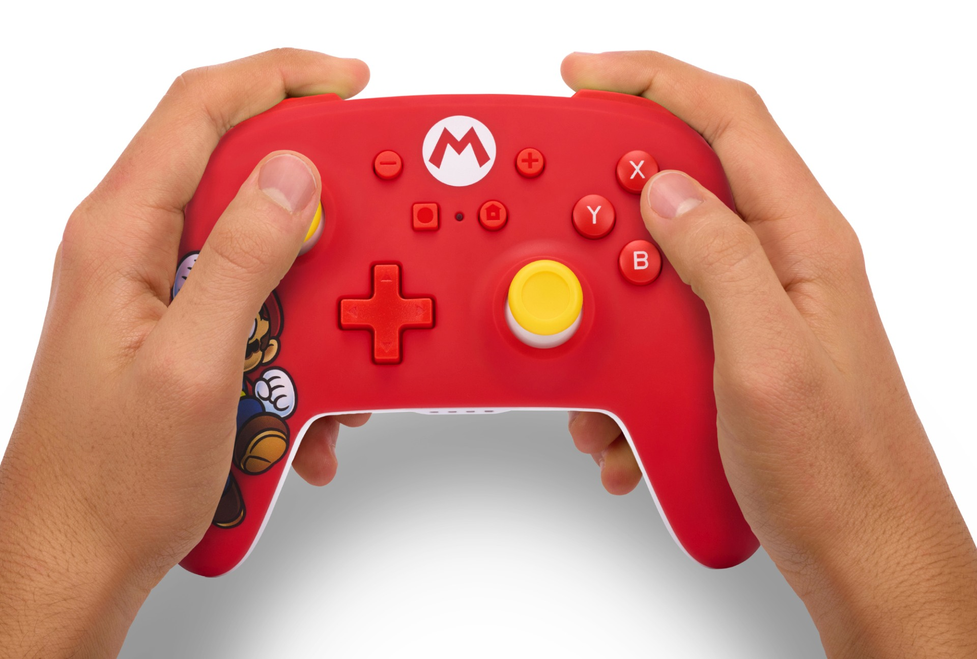 Dłonie trzymające czerwony kontroler gier z motywem Mario i żółtymi joystickami.