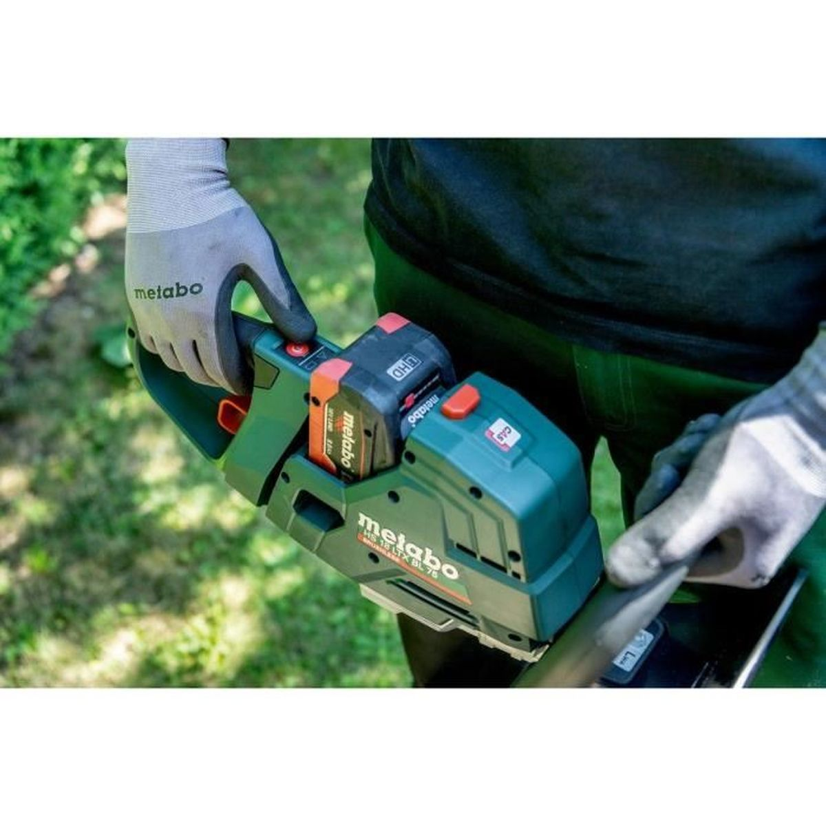Person mit Schutzhandschuhen hält einen grünen Metabo Heckenschneider mit Akkus.