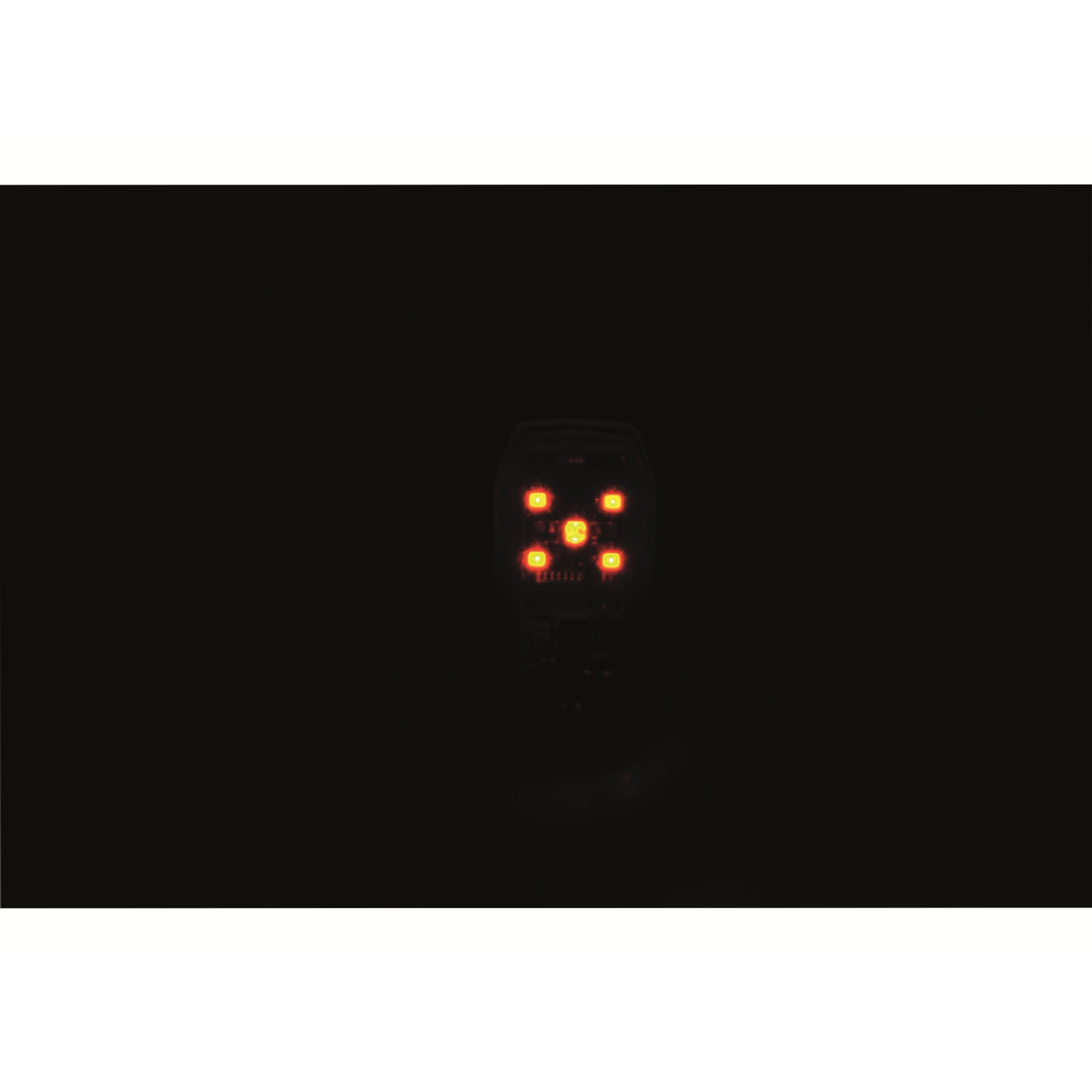 Ein einzelnes, leuchtend rotes LED-Rücklicht im Dunkeln.