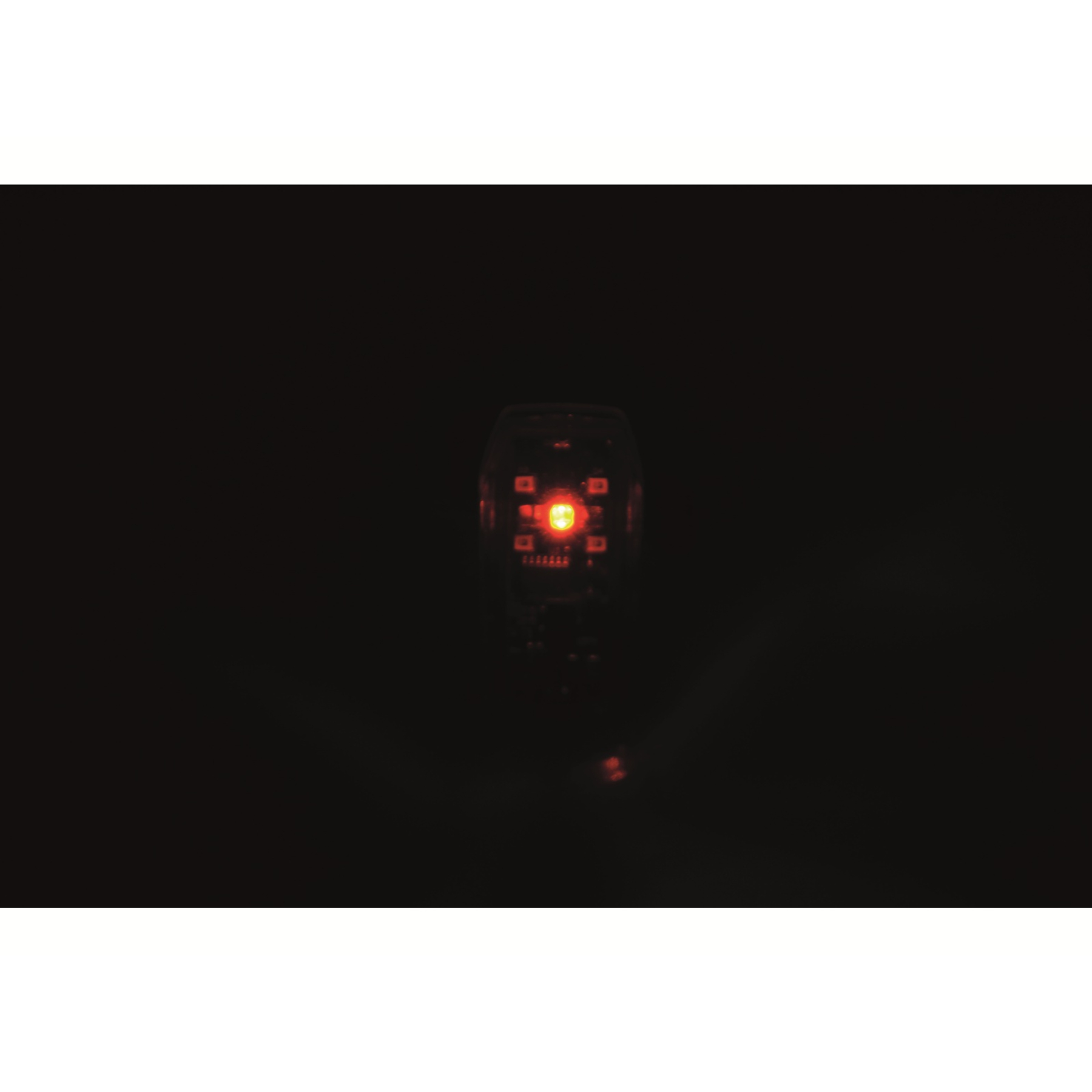 Ein rotes LED-Licht leuchtet in einem dunklen Raum.