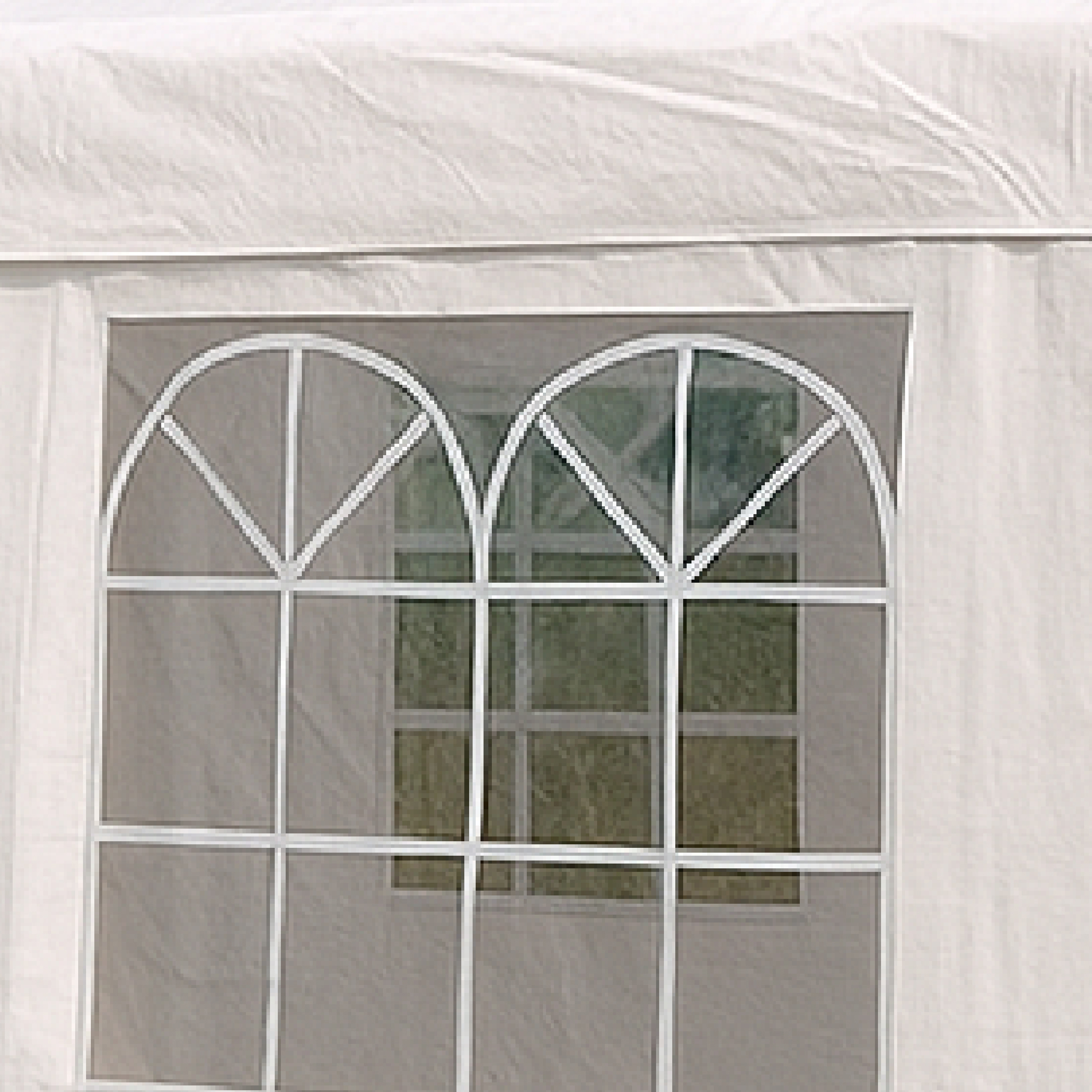 Zwei weiße, bogenförmige Fenster mit Gittern, die auf grünes Gras blicken.