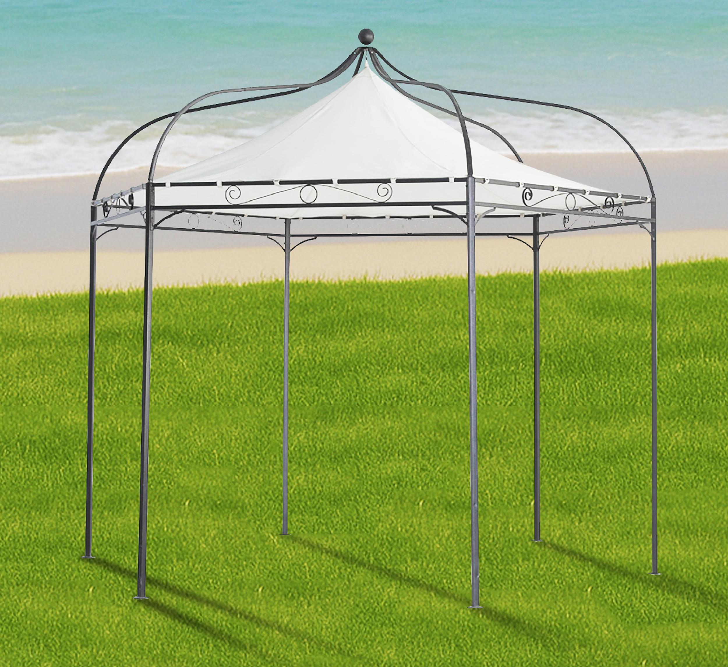 Ein weißes Pavillon steht auf grünem Gras am Strand mit dem Meer im Hintergrund.