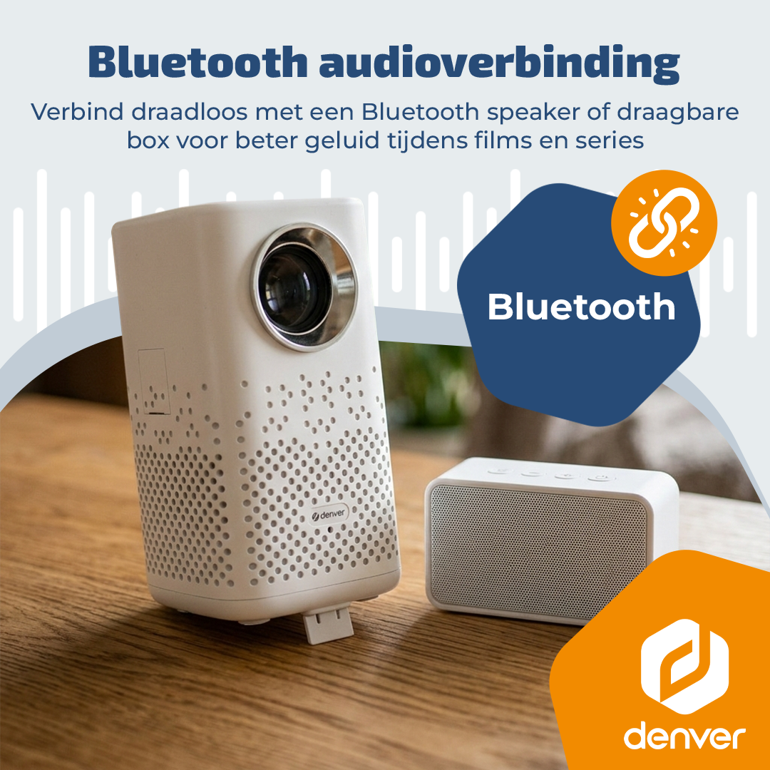 Un projecteur blanc et une enceinte Bluetooth blanche sur une table en bois.