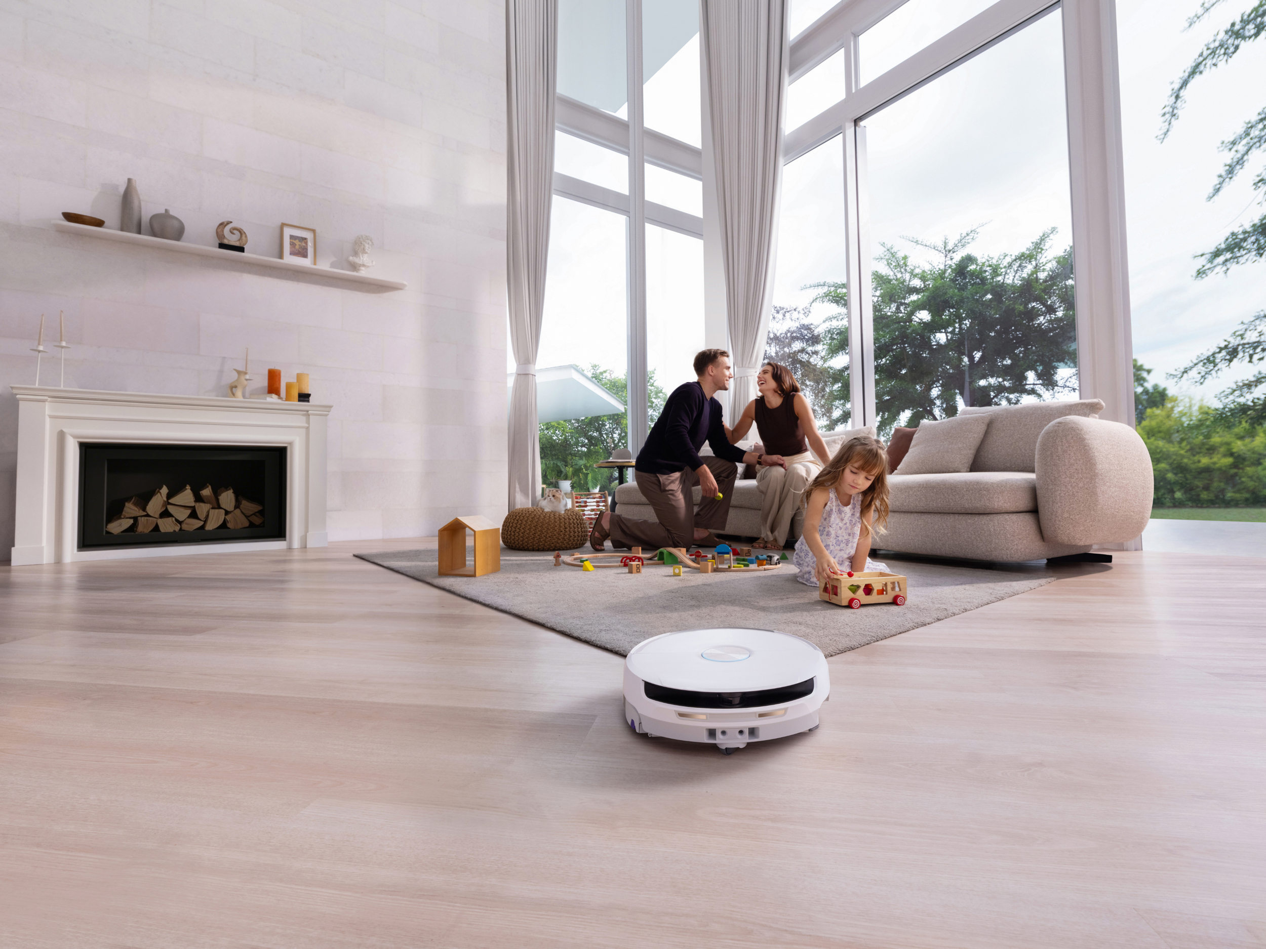 Een robotstofzuiger reinigt de vloer terwijl een gezin speelt.