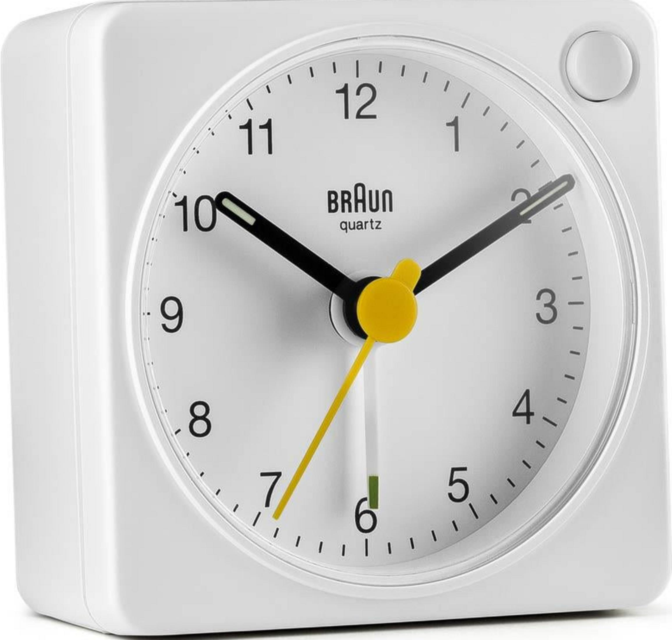 Un réveil Braun blanc avec aiguilles noires et trotteuse jaune.