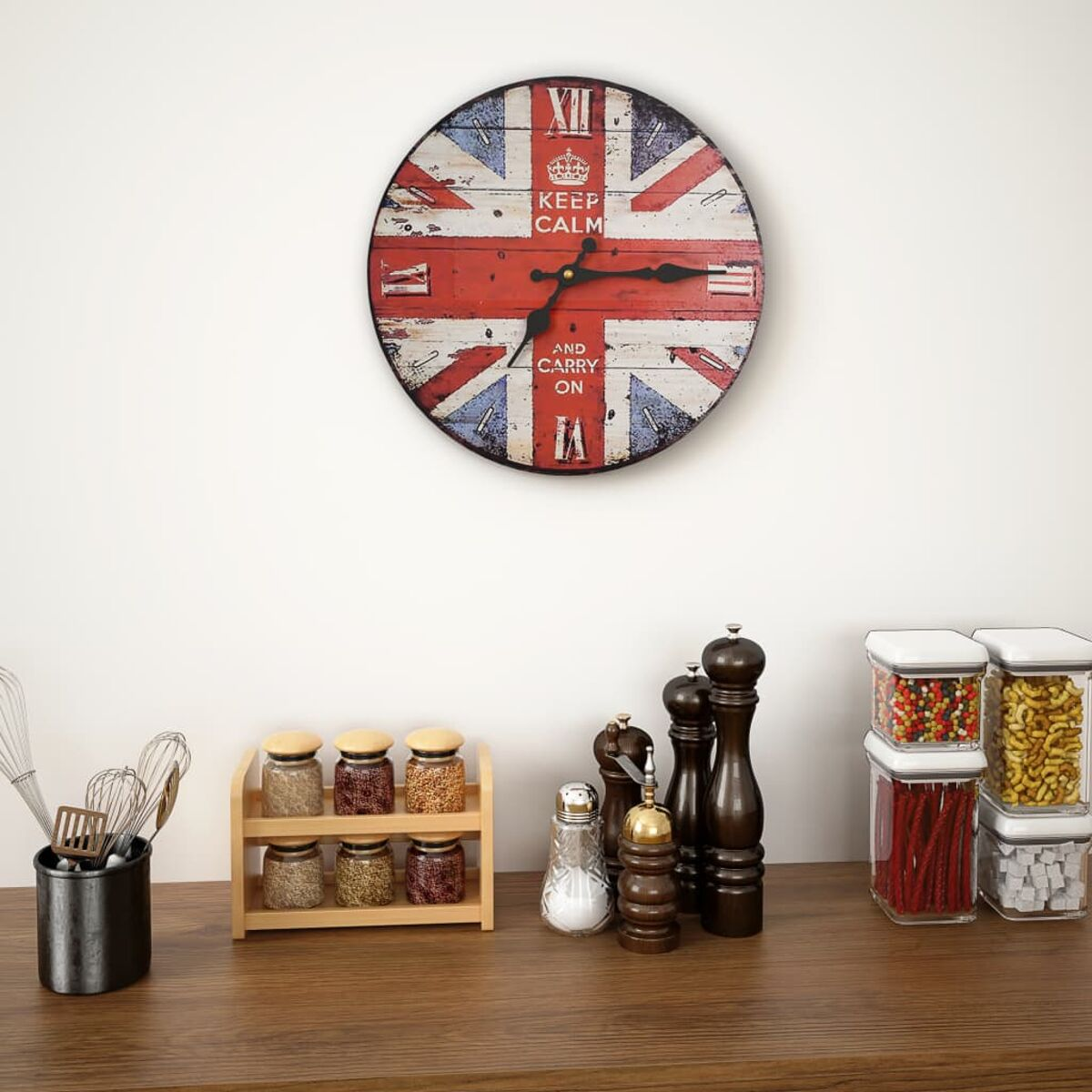 Eine Uhr im Union-Jack-Design hängt an der Wand. Darunter stehen Gewürzgläser, Pfeffermühlen und Vorratsbehälter.
