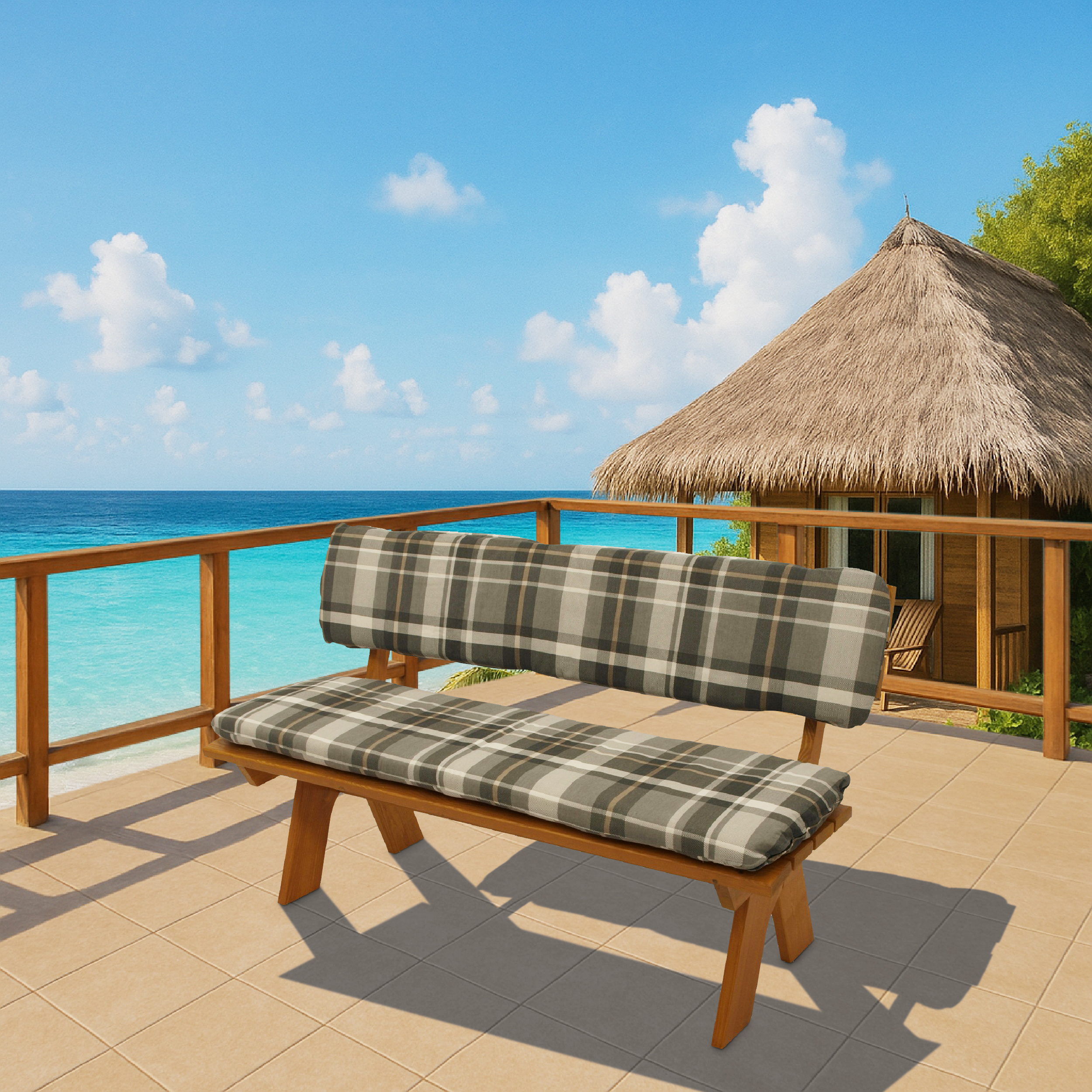 Holzbank mit karierten Kissen auf einer Terrasse mit Blick auf das Meer und ein Strohdachhaus.