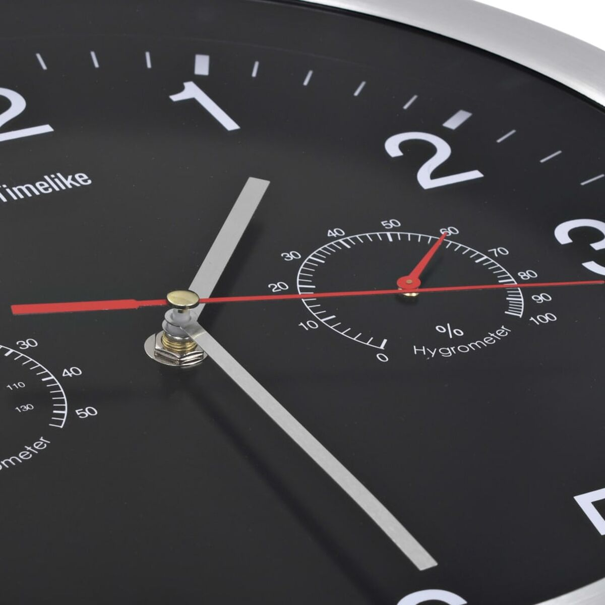 Ein schwarzes Zifferblatt mit weißen Zahlen, einem Hygrometer und silbernen Zeigern.