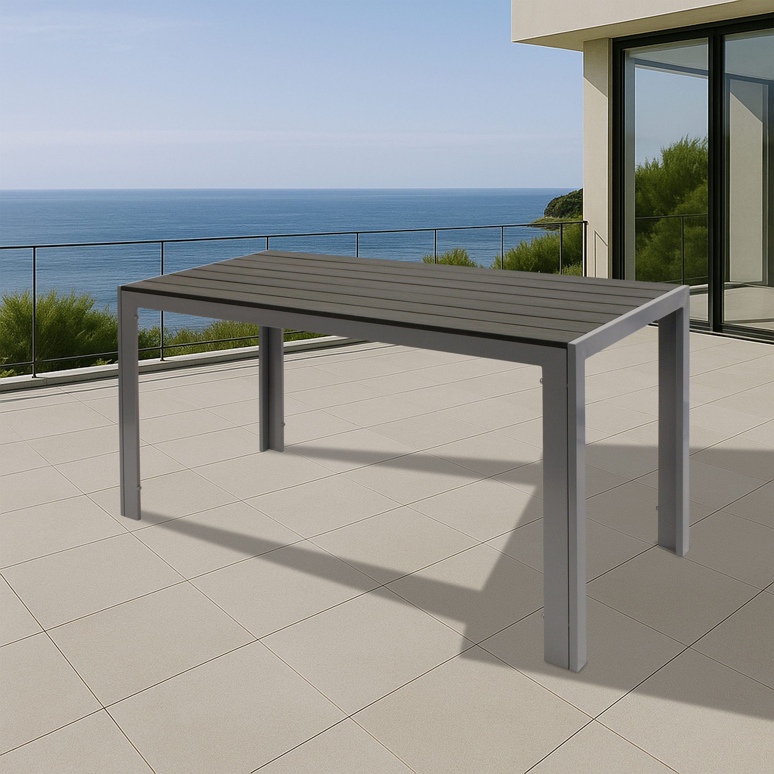 Ein grauer Tisch mit Lamellenplatte steht auf einer gefliesten Terrasse am Meer.