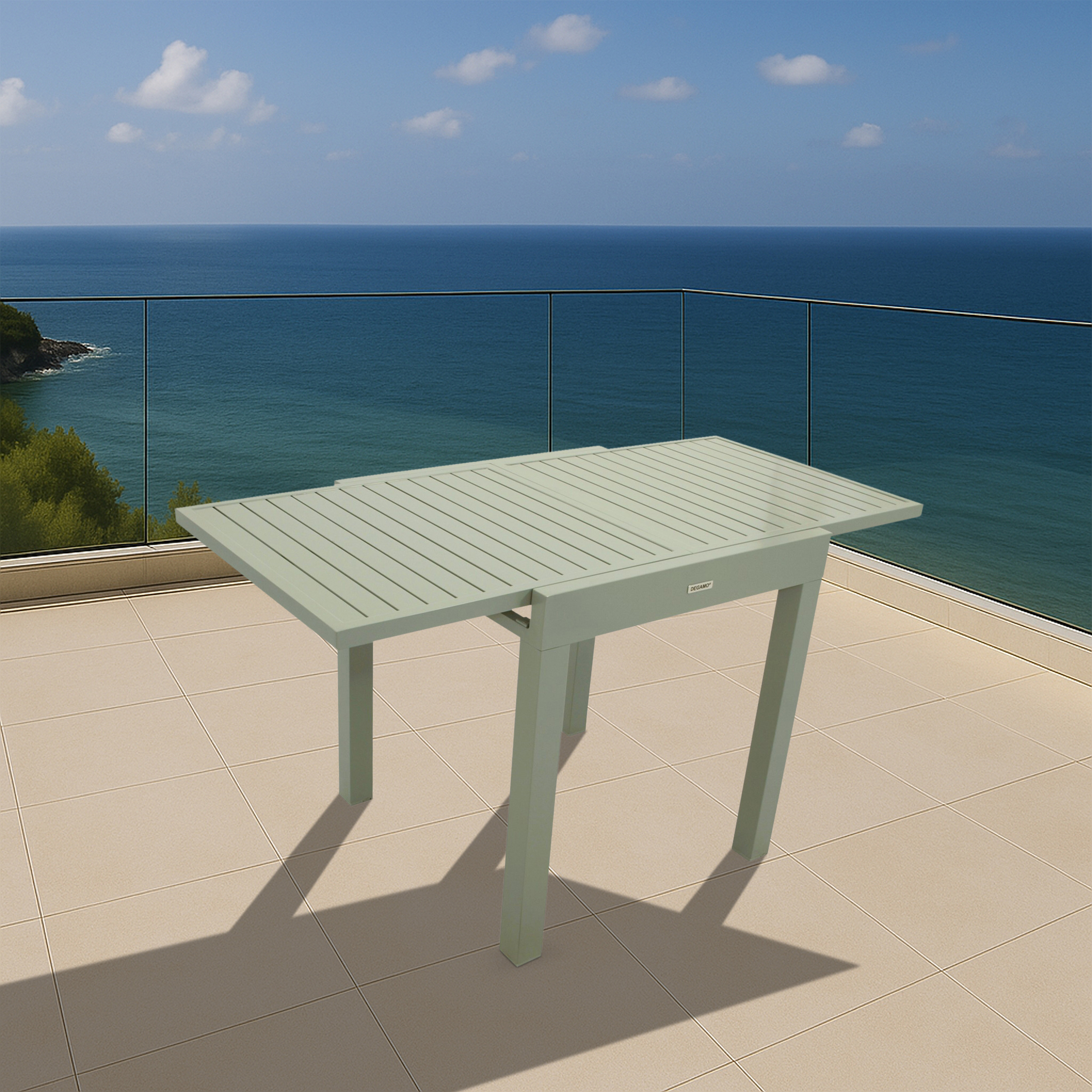 Ein hellgrüner Tisch steht auf einer gefliesten Terrasse mit Blick auf das Meer und den Himmel.