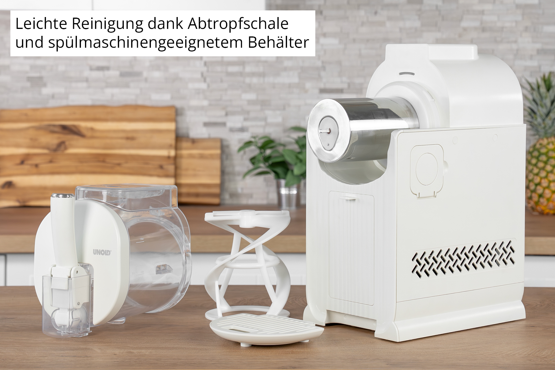 Un elettrodomestico da cucina bianco con accessori, contenitore e frusta su tavolo legno.