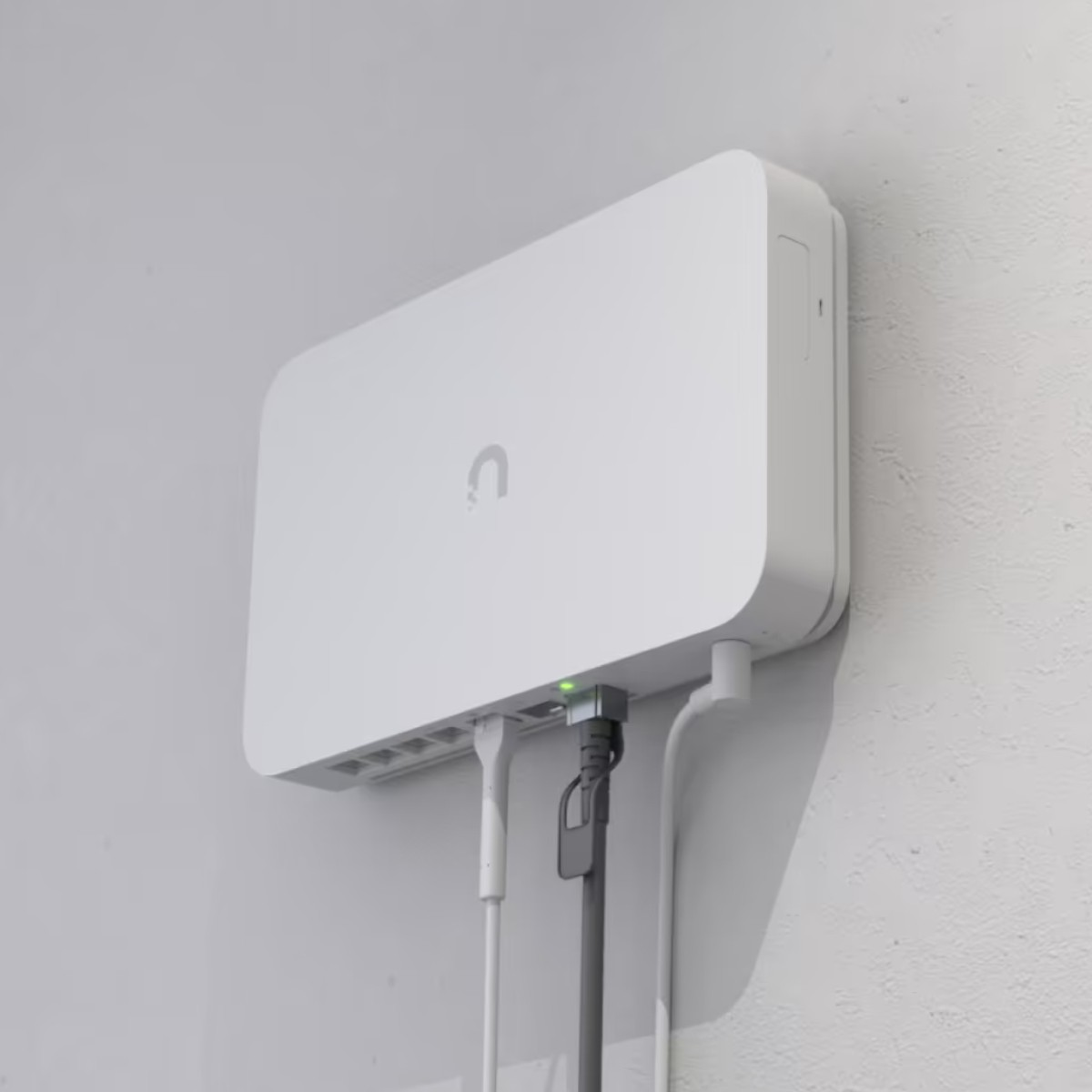 Un dispositivo bianco con cavi è montato su un muro con diverse porte.