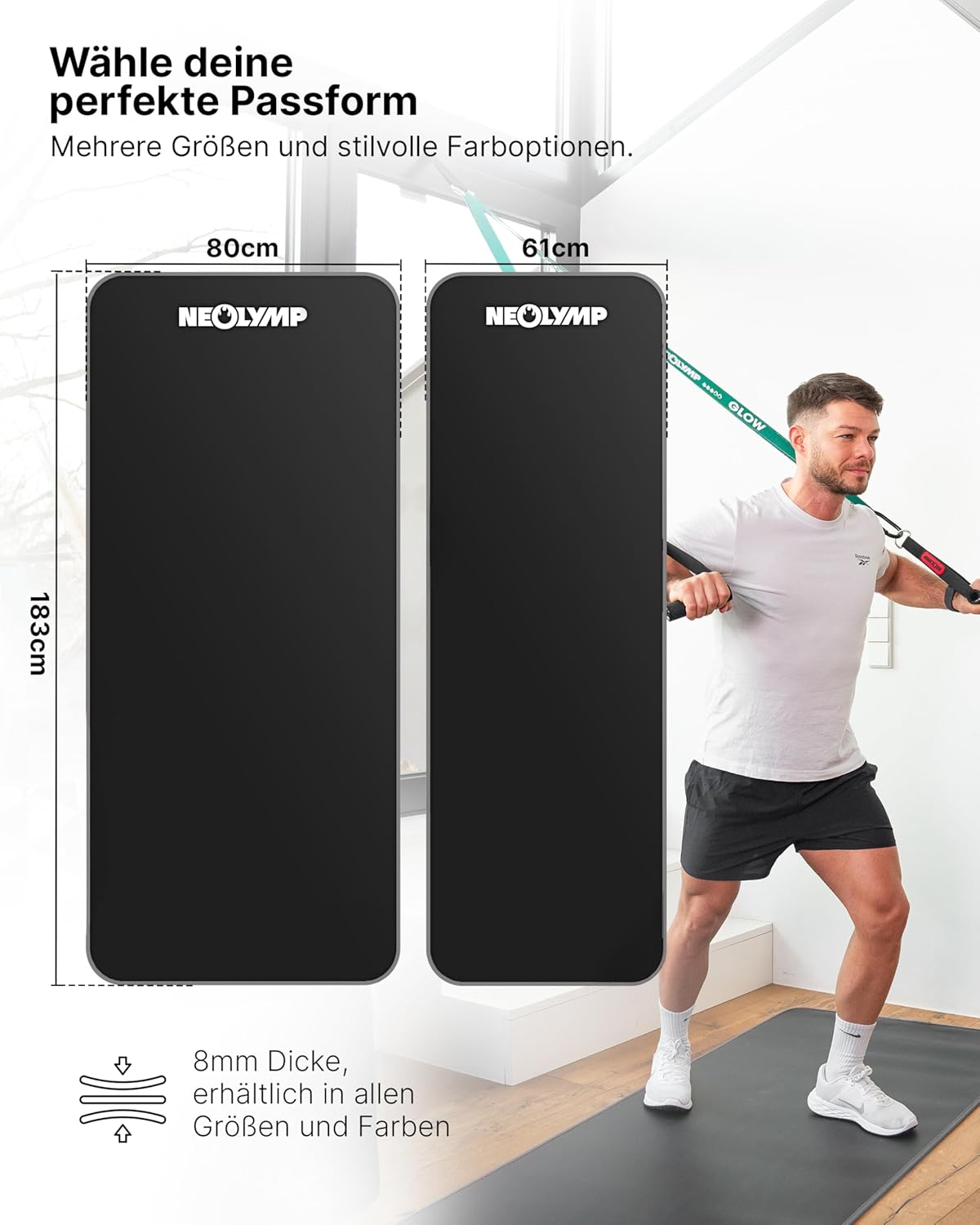 Zwei schwarze Yogamatten, eine 80cm und eine 61cm breit. Ein Mann trainiert im Hintergrund.