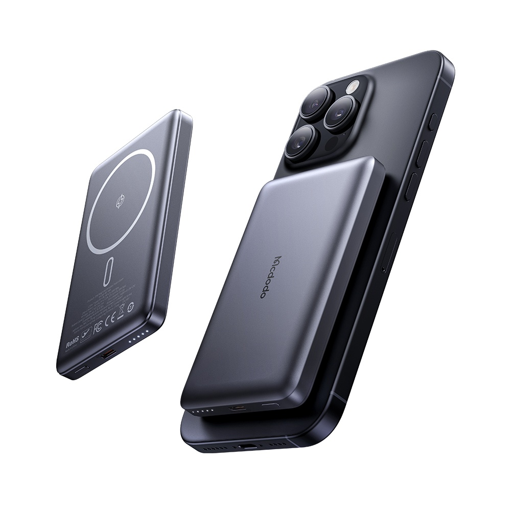 Ein graues iPhone mit angebrachtem Ladegerät und ein weiteres Ladegerät daneben.