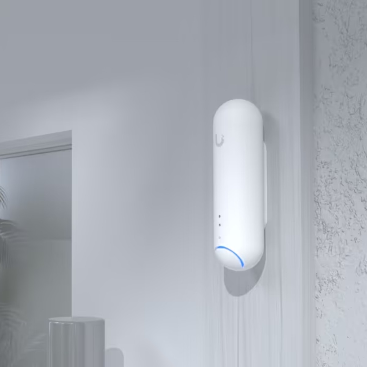 Un dispositivo bianco con luce blu montato a parete.