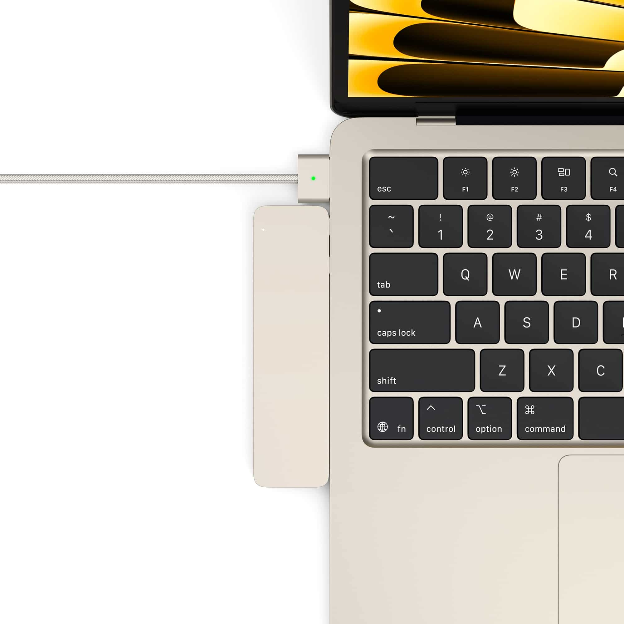 A cream-colored laptop with a USB-C hub and cable connected.