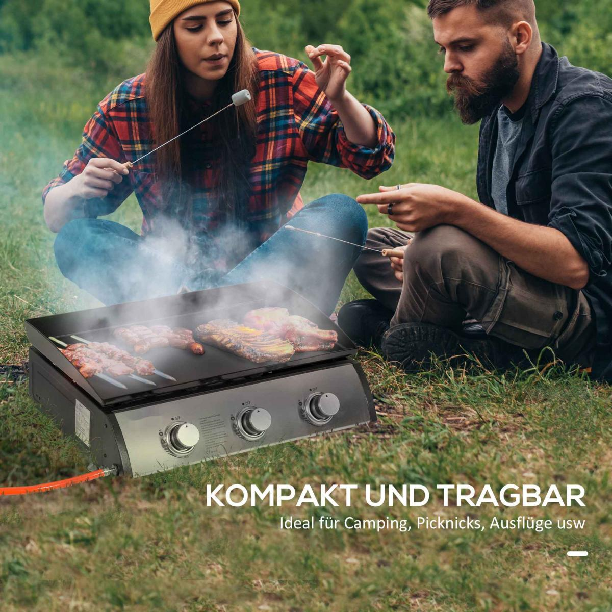 Zwei Personen grillen Fleisch und Marshmallows im Freien auf einem tragbaren Grill.