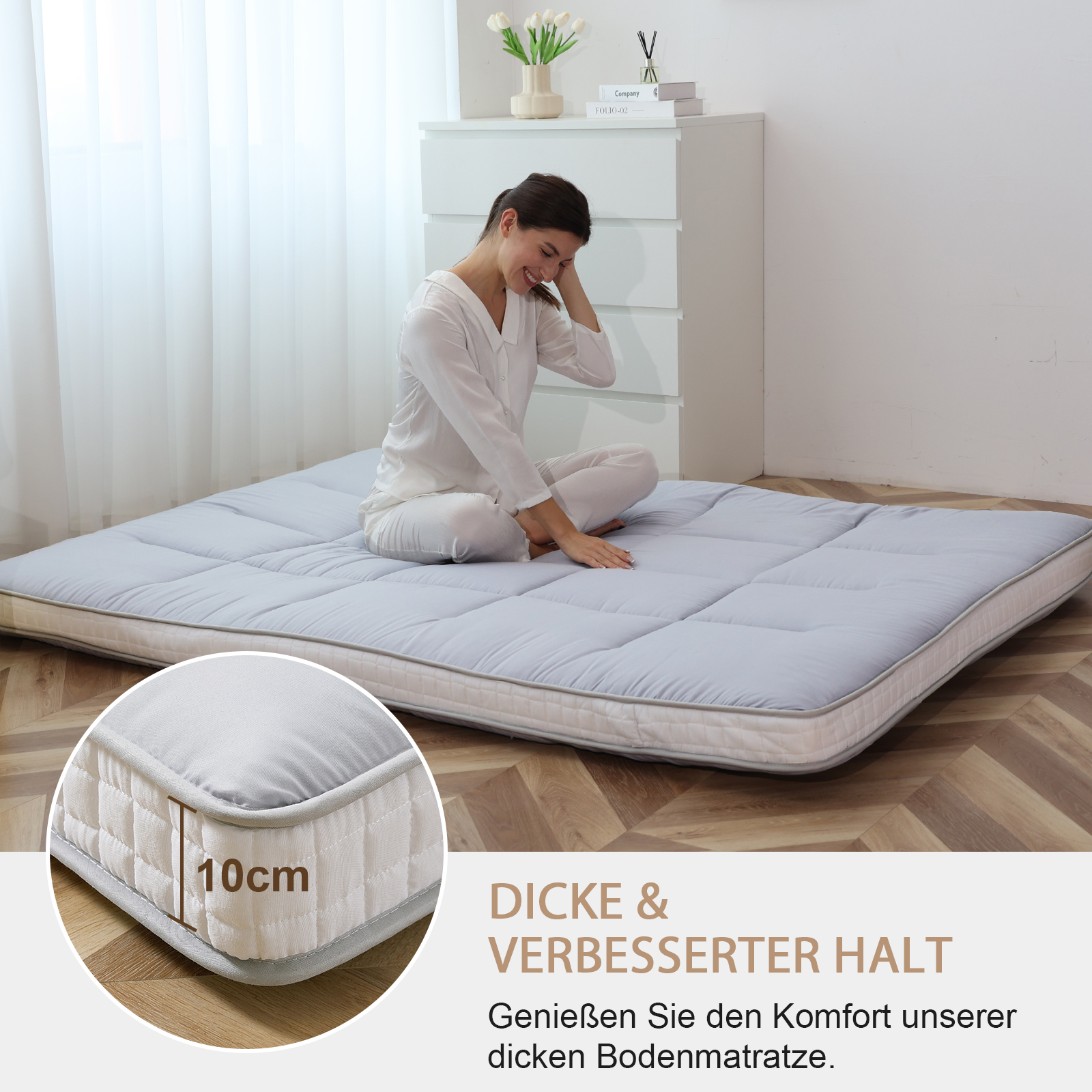 Eine Frau sitzt auf einer grauen Matratze. Ein Detail zeigt die 10cm Dicke.