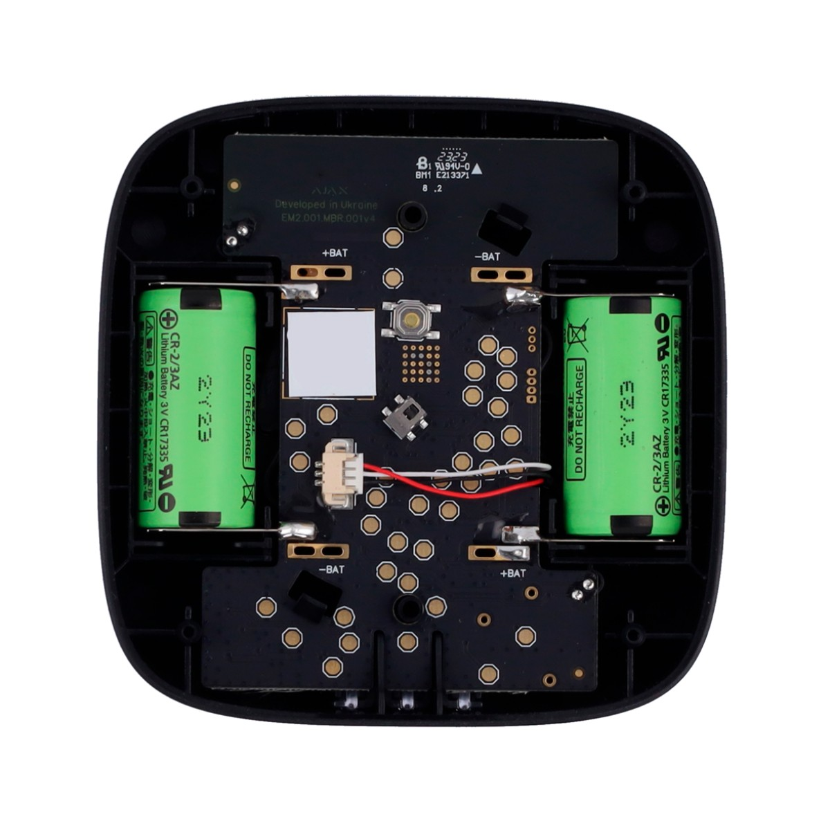 Interior de un dispositivo negro con dos baterías verdes, una placa de circuito y cables.