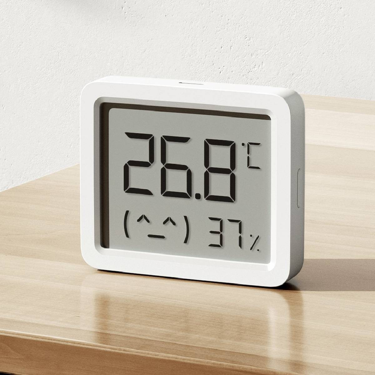 Un termometro digitale bianco mostra 26,8 gradi e 37% di umidità.