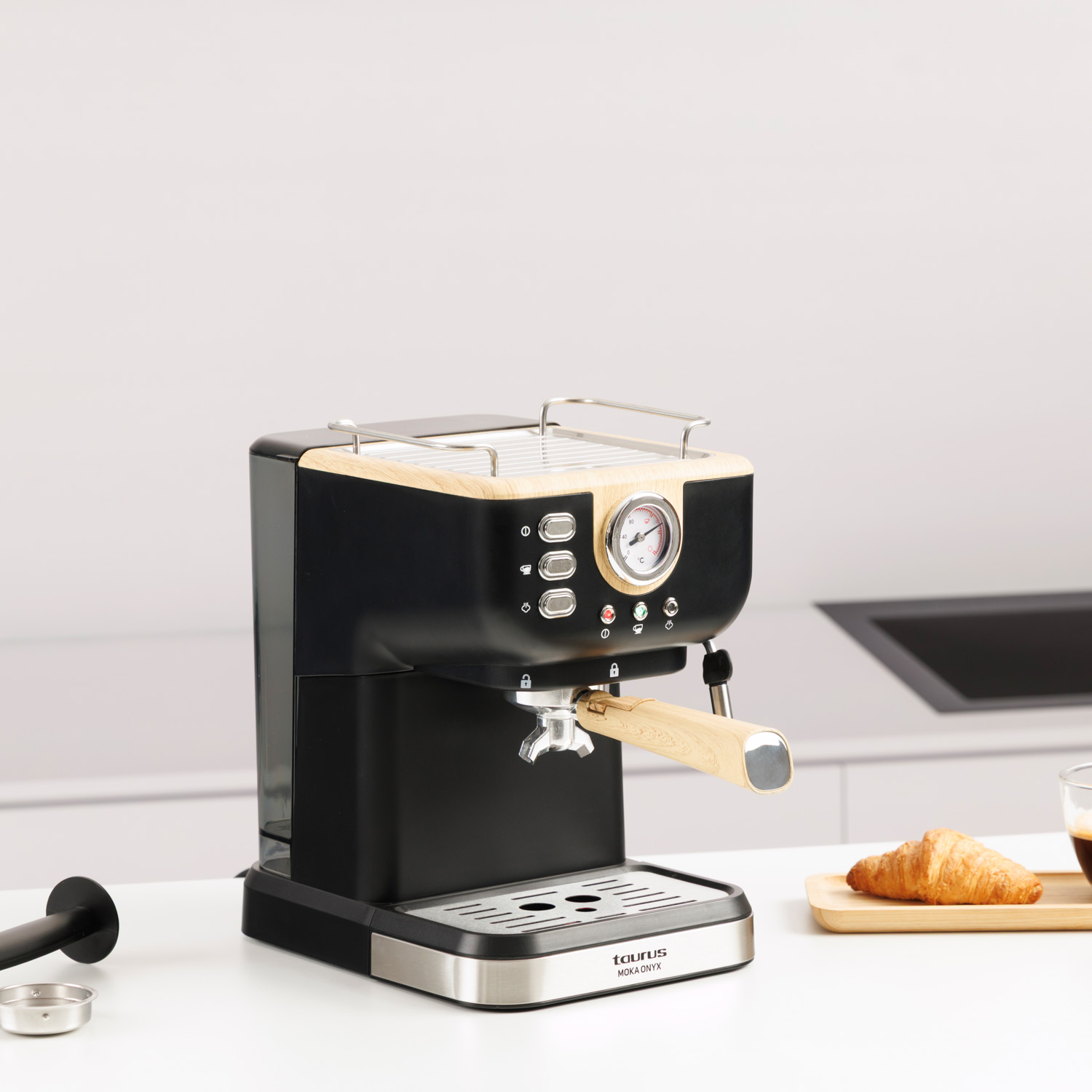Una cafetera espresso negra con detalles de madera sobre una encimera blanca.