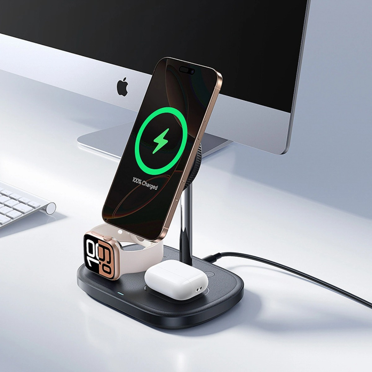 Un iPhone dorato, un Apple Watch e auricolari bianchi si caricano su un supporto nero.